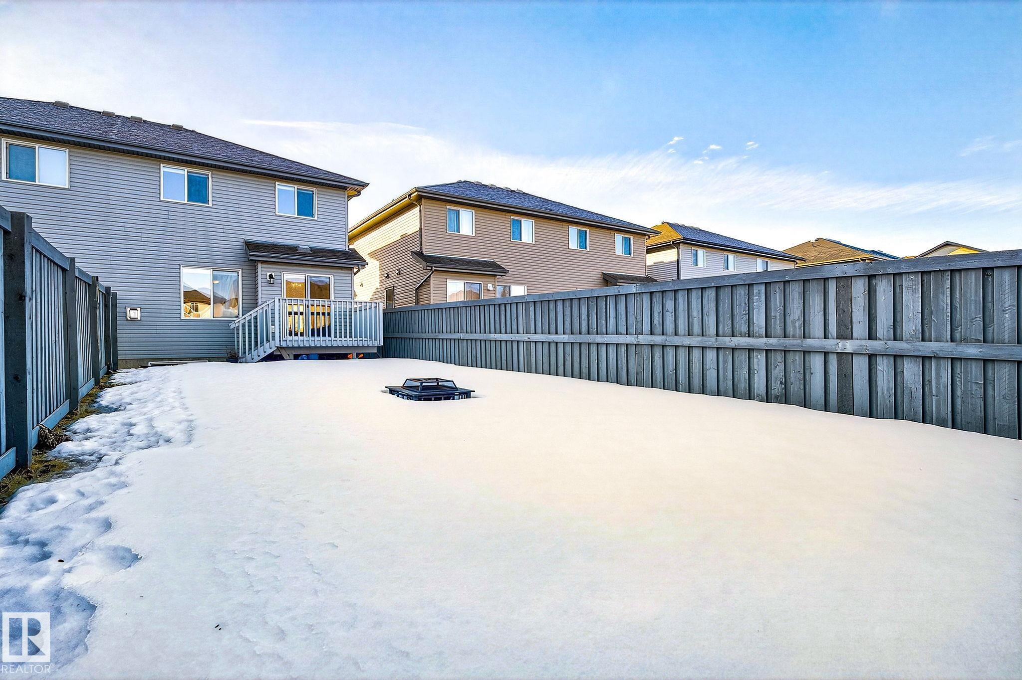 Rear view of house with a fenced backyard, a fire pit, and a wooden deck - 2338 Casselman Crescent, Edmonton, AB - Outdoor With Exterior
