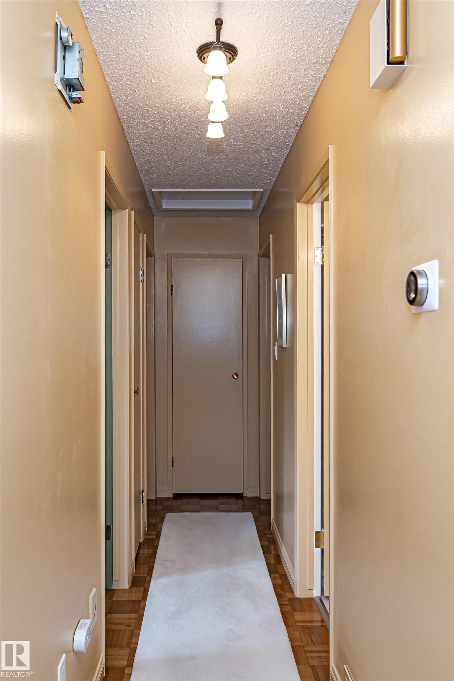 Hall with a textured ceiling and parquet flooring - 2112 67 Street Nw, Edmonton, AB - Indoor Photo Showing Other Room
