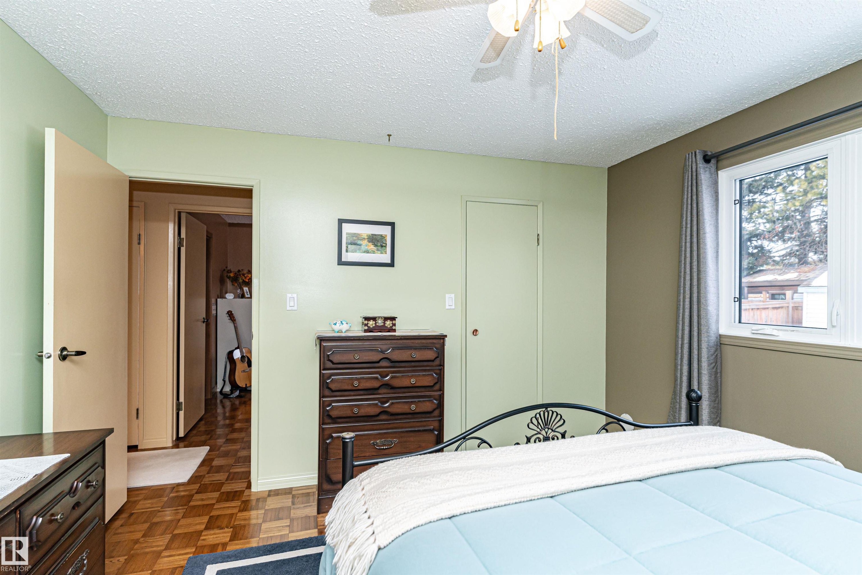 Bedroom with a textured ceiling, parquet flooring, a closet, and ceiling fan - 2112 67 Street Nw, Edmonton, AB - Indoor Photo Showing Bedroom