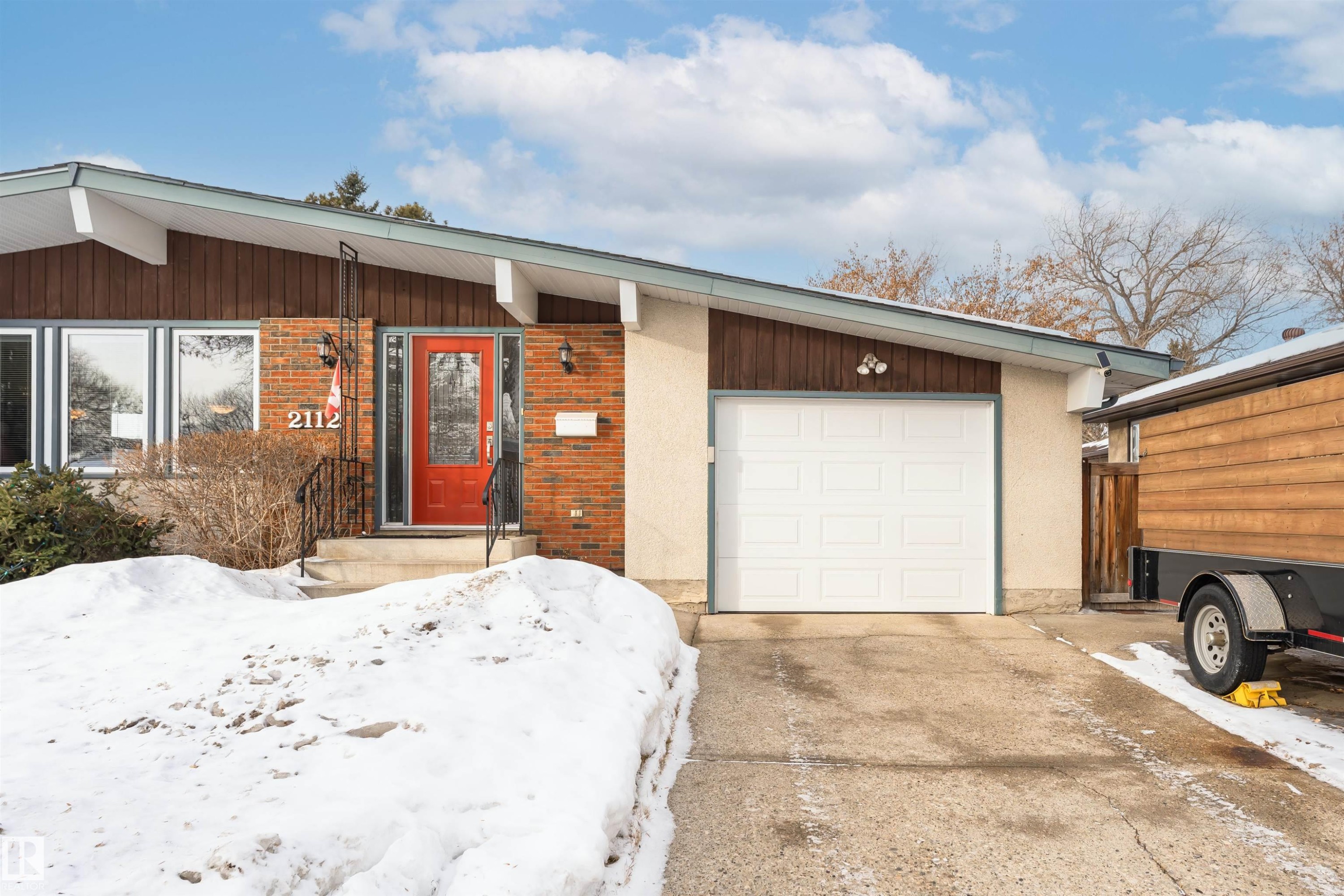 View of front facade featuring brick siding, concrete driveway, and an attached garage - 2112 67 Street Nw, Edmonton, AB - Outdoor