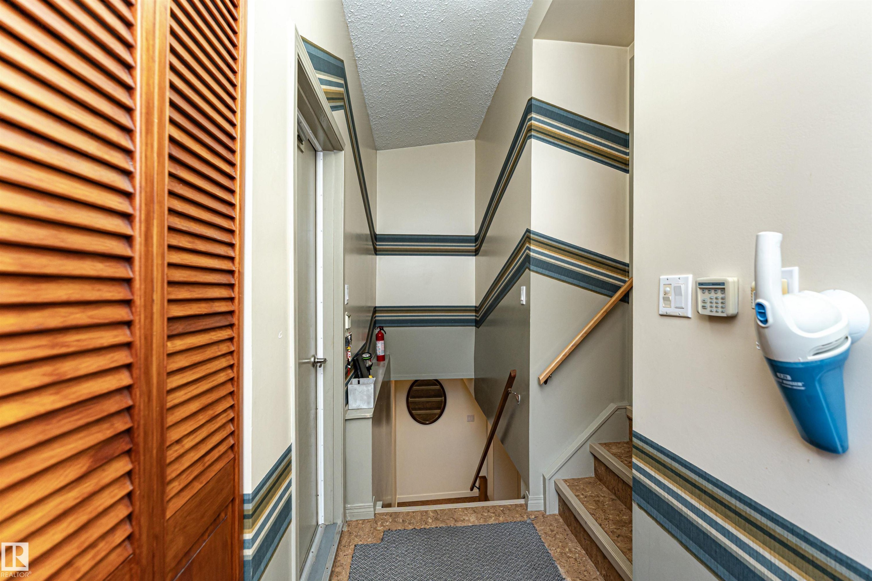 Stairway featuring a textured ceiling and baseboards - 2112 67 Street Nw, Edmonton, AB - Photo Showing Other Room