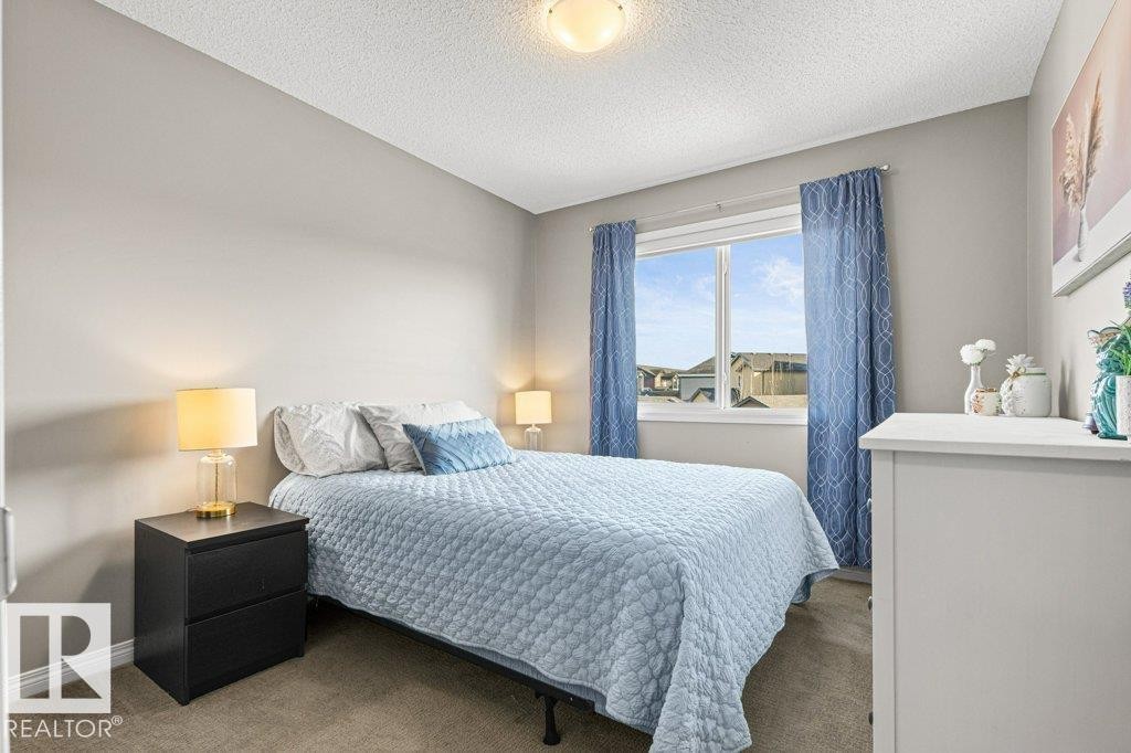Carpeted bedroom with a textured ceiling and baseboards - 3351 Orchards Link, Edmonton, AB - Indoor Photo Showing Bedroom