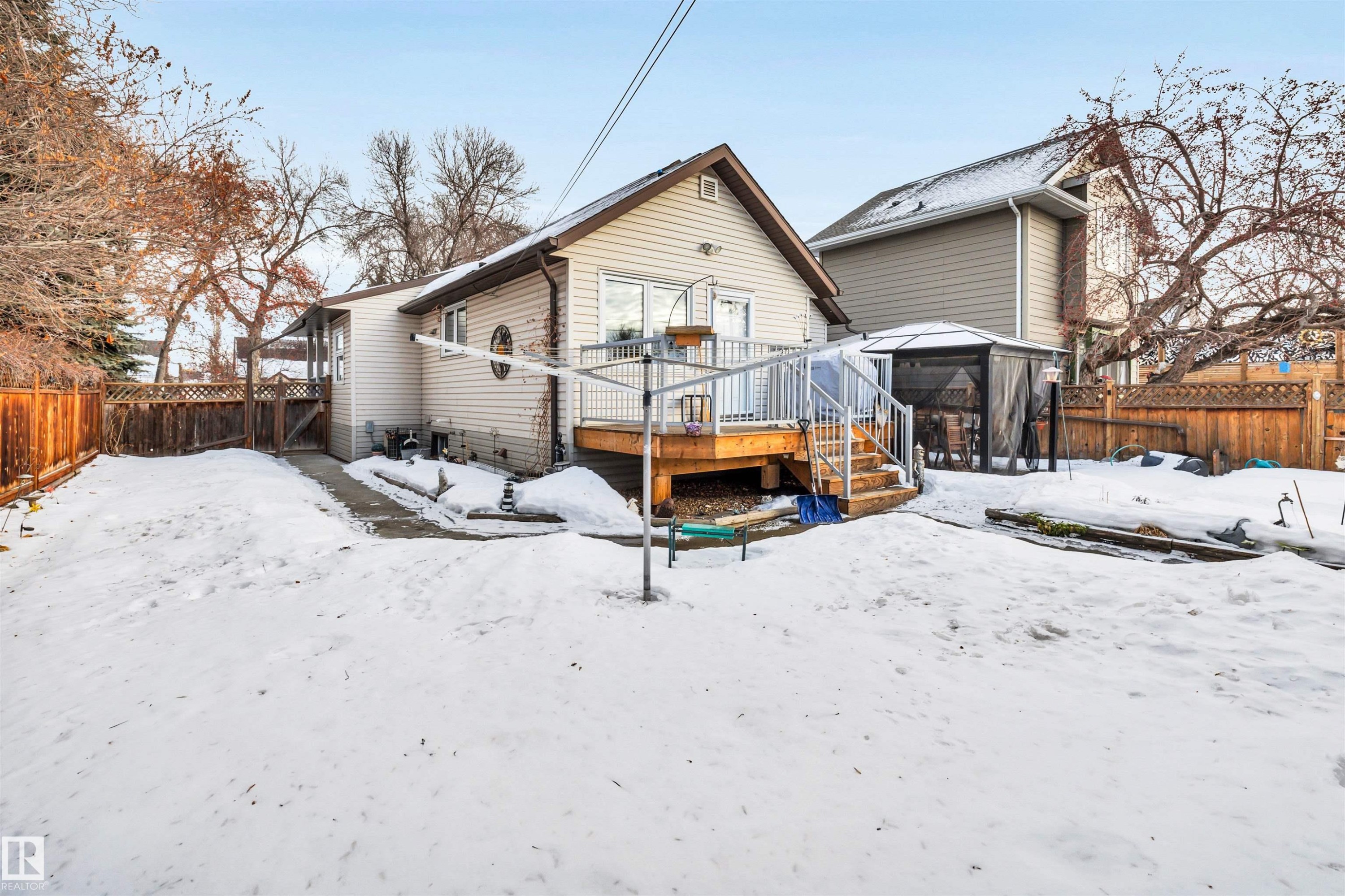 Snow covered back of property with a fenced backyard and a wooden deck - 11432 71 Street, Edmonton, AB - Outdoor