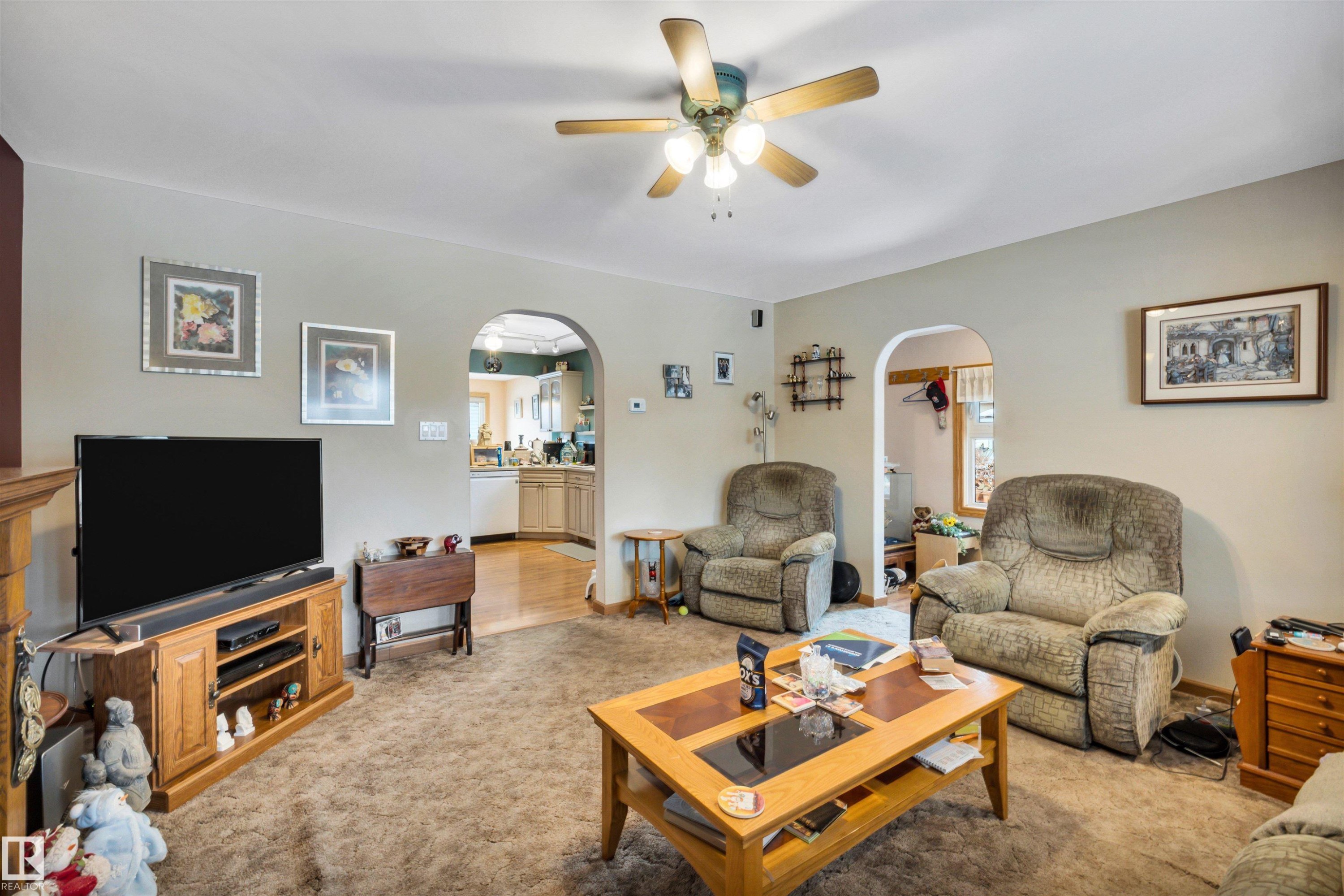 Living area featuring arched walkways, a ceiling fan, and light colored carpet - 11432 71 Street, Edmonton, AB - Indoor Photo Showing Living Room
