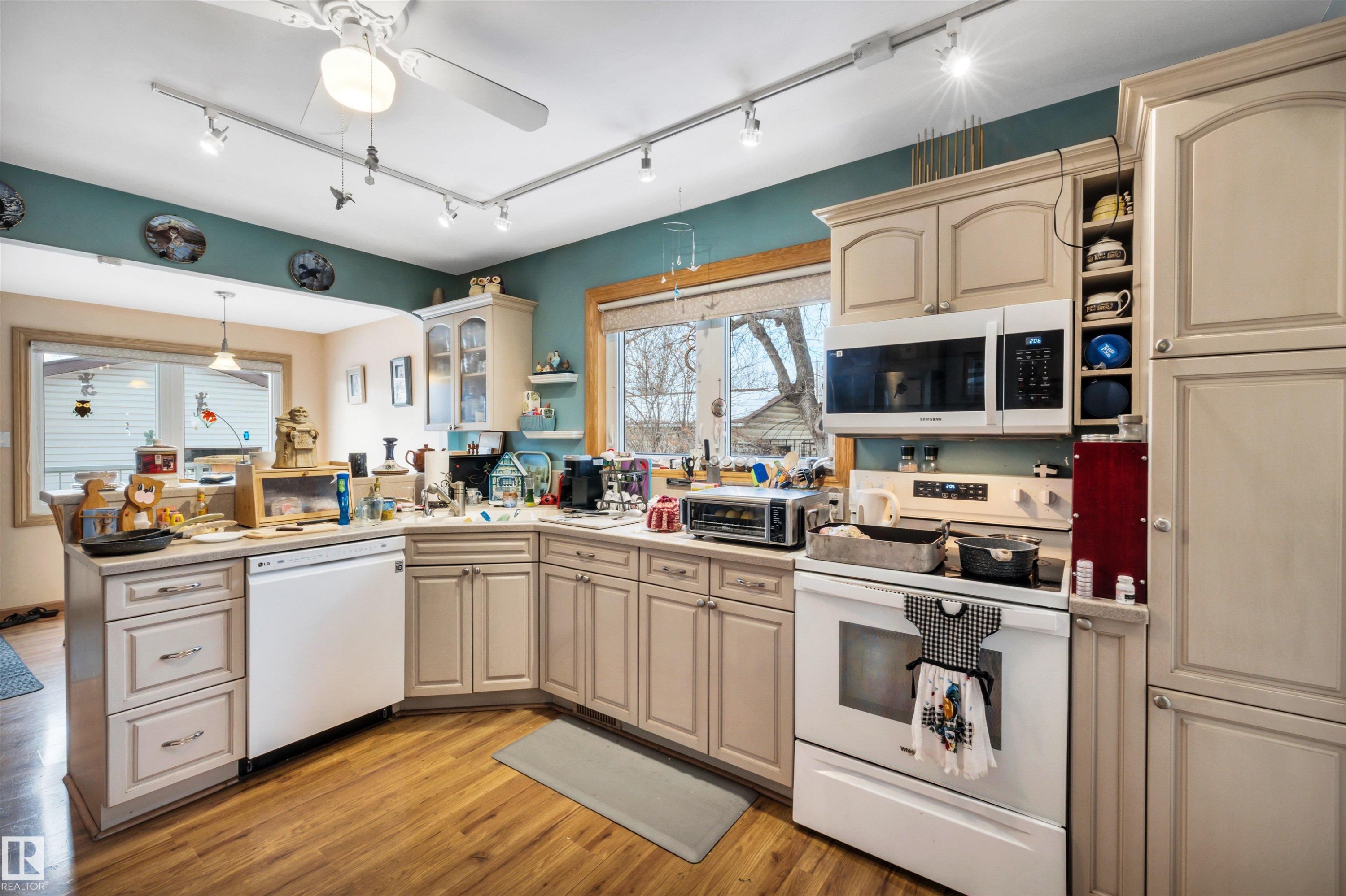 Kitchen with white appliances, cream cabinets, open shelves, track lighting, and ceiling fan - 11432 71 Street, Edmonton, AB - Indoor Photo Showing Kitchen