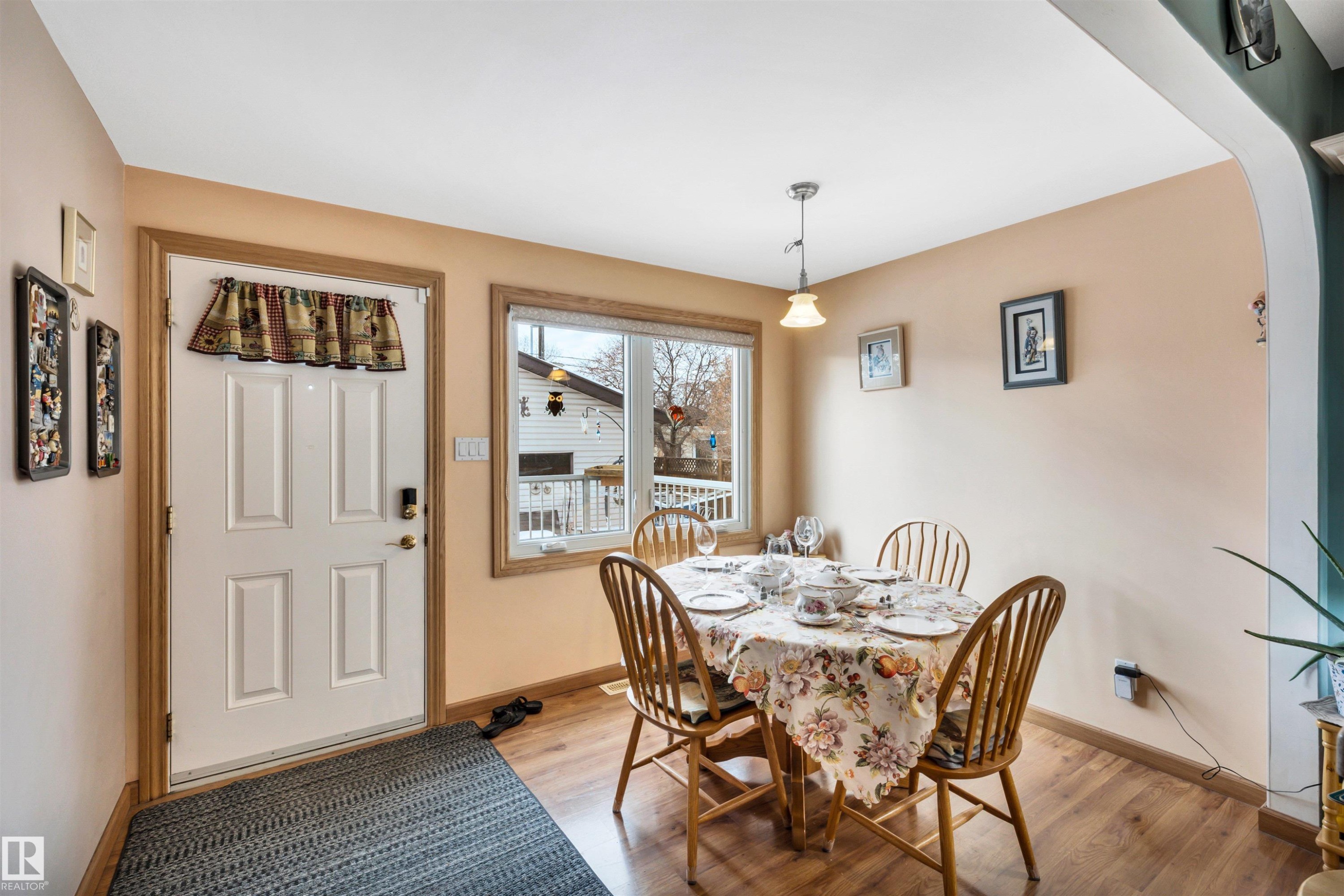 Dining area with light wood-style floors and arched walkways - 11432 71 Street, Edmonton, AB - Indoor Photo Showing Dining Room