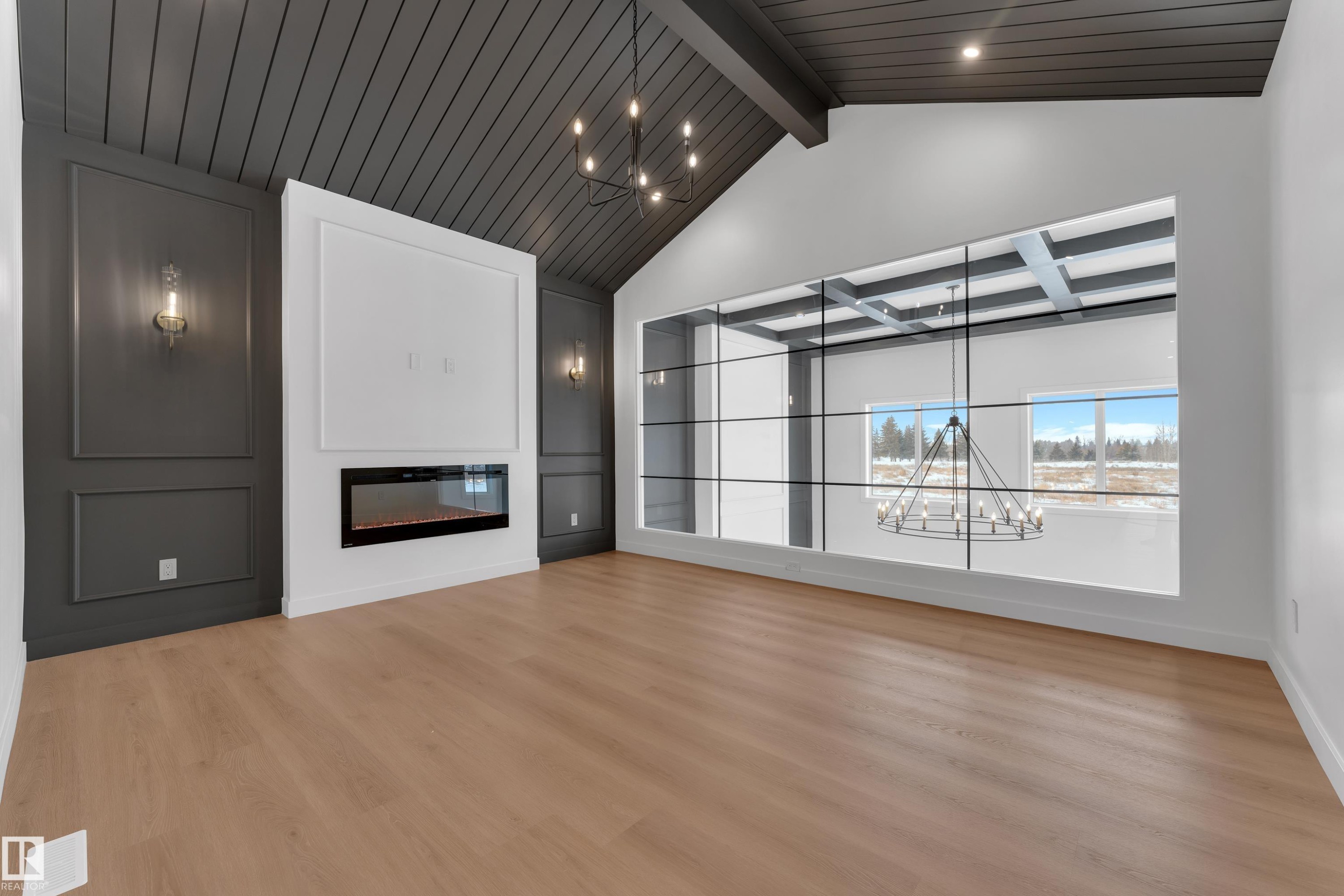 Unfurnished living room with a chandelier, a glass covered fireplace, and light wood-style flooring - 40 Grayson Green, Stony Plain, AB - Indoor With Fireplace