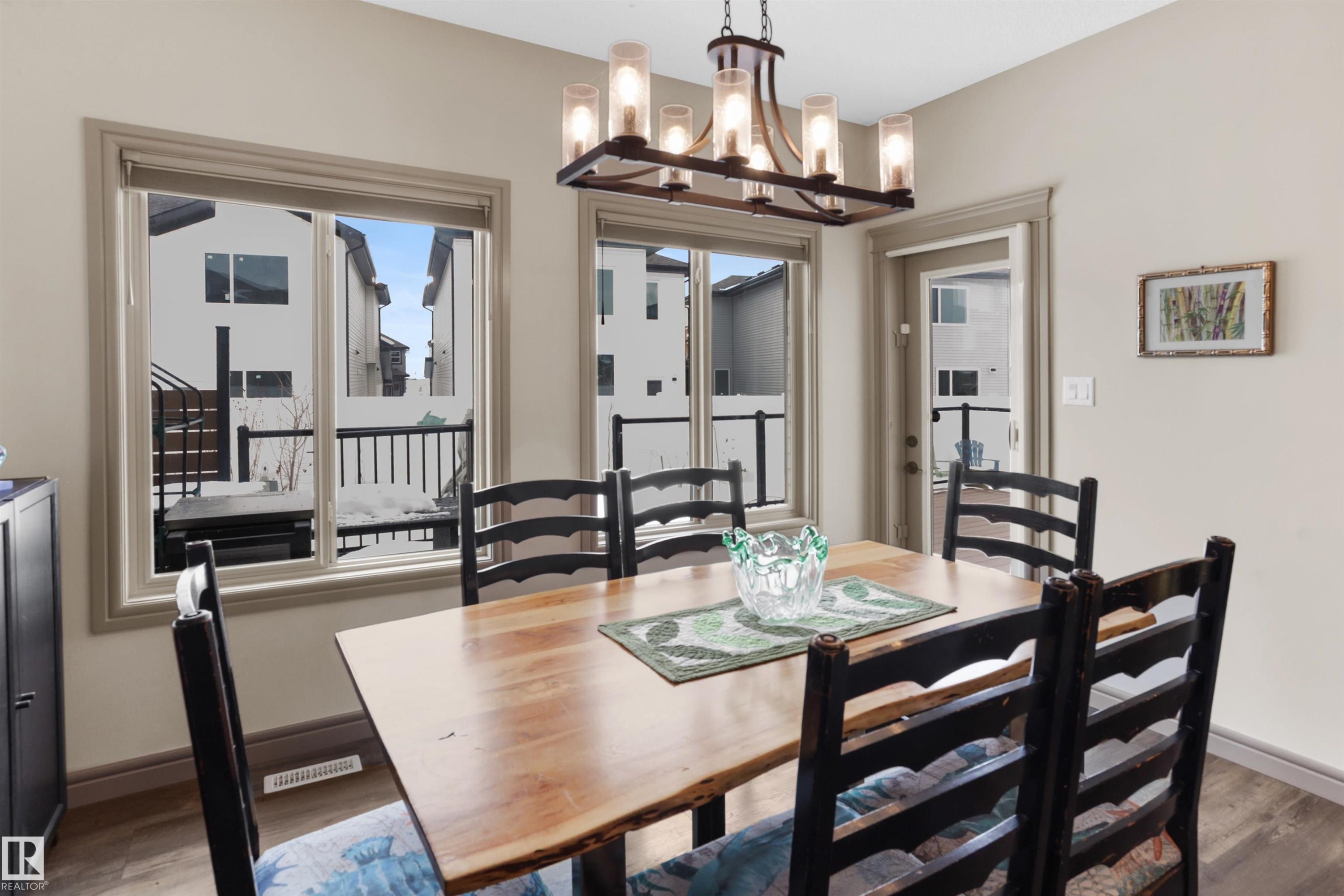 Dining room with a chandelier and dark wood-style flooring - 97 Astoria Point(E), Devon, AB - Indoor Photo Showing Dining Room
