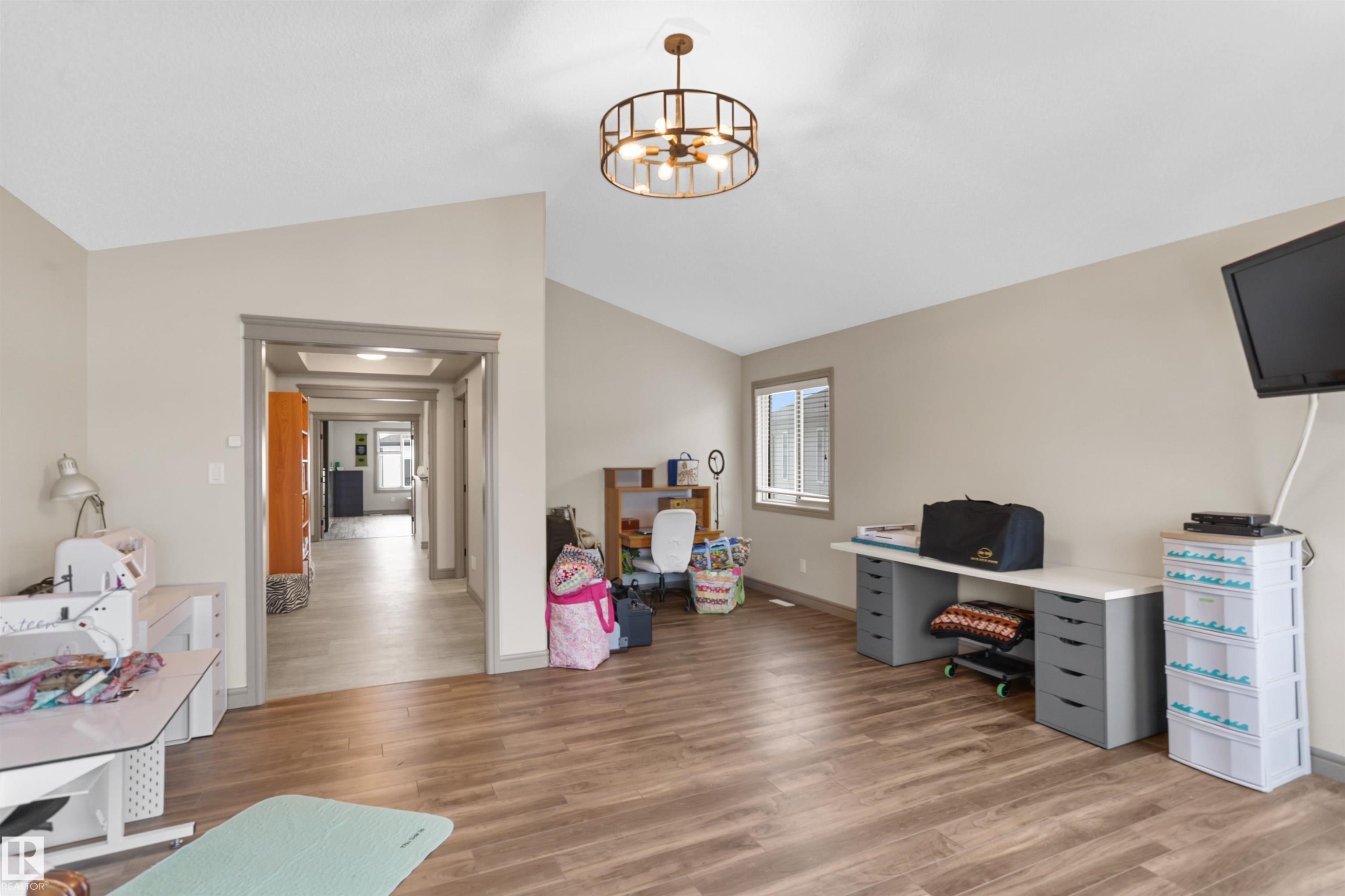 Home office with light wood-style flooring, vaulted ceiling, and hanging lights - 97 Astoria Point(E), Devon, AB - Indoor