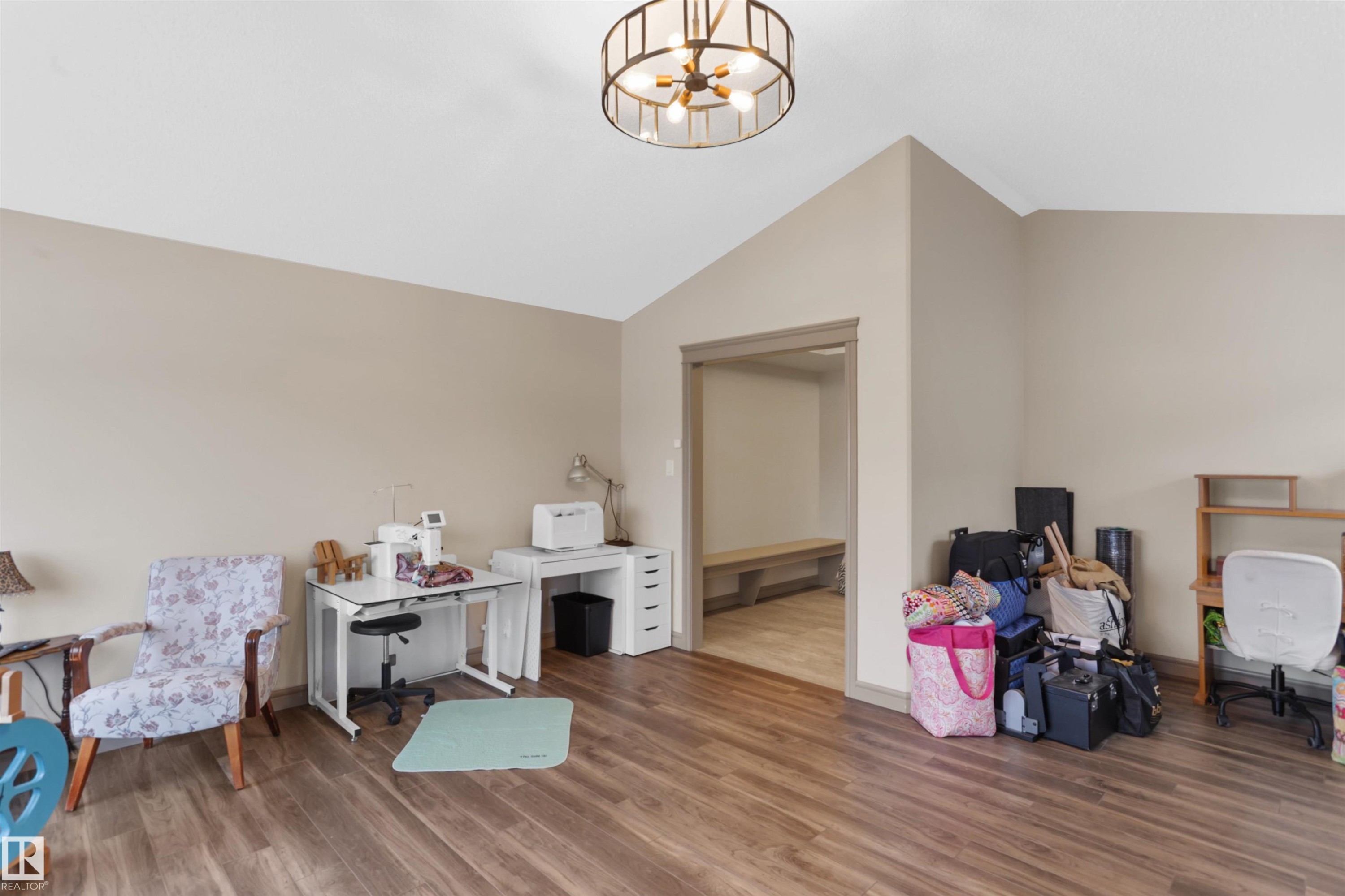 Office featuring wood finished floors, suspended lighting, and vaulted ceiling - 97 Astoria Point(E), Devon, AB - Indoor