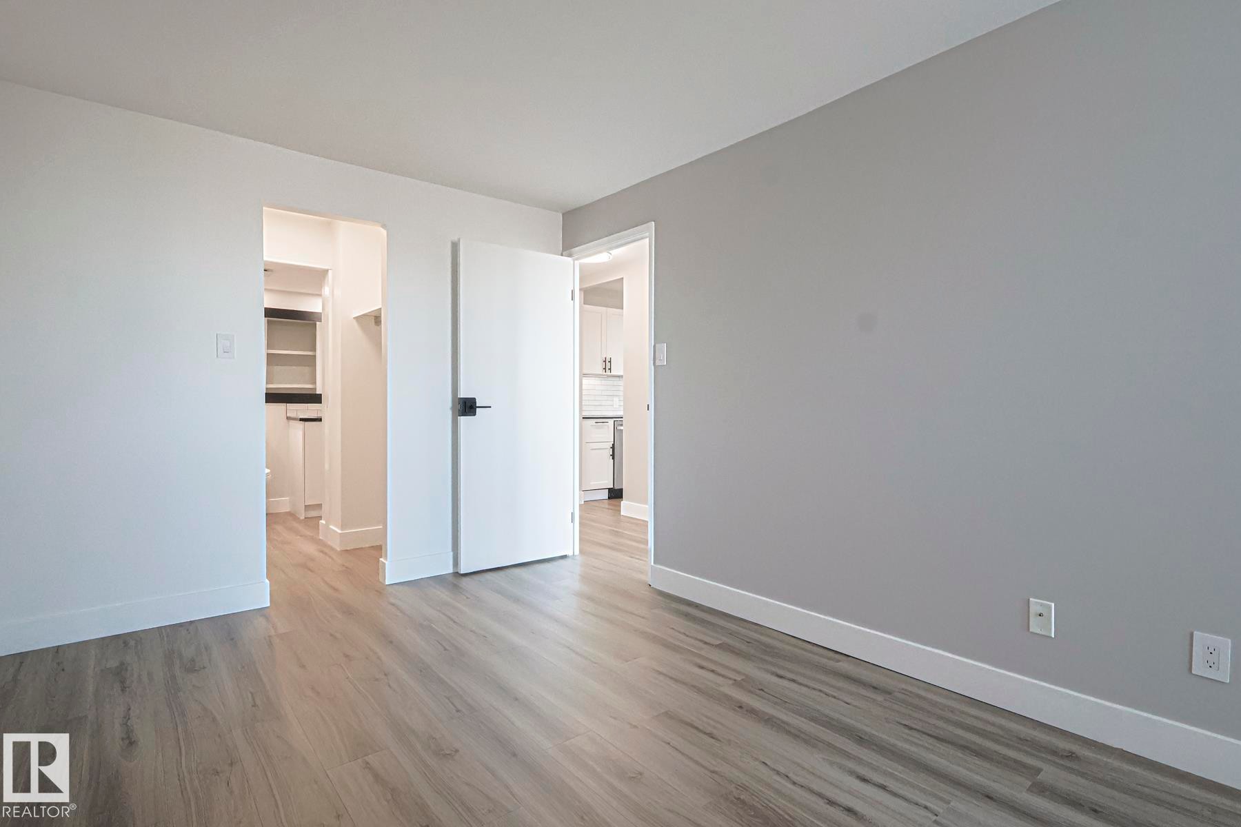 Primary bedroom with a spacious closet and light wood-style vinyl plank floors - 505 10149 Saskatchewan Drive, Edmonton, AB - Indoor Photo Showing Other Room