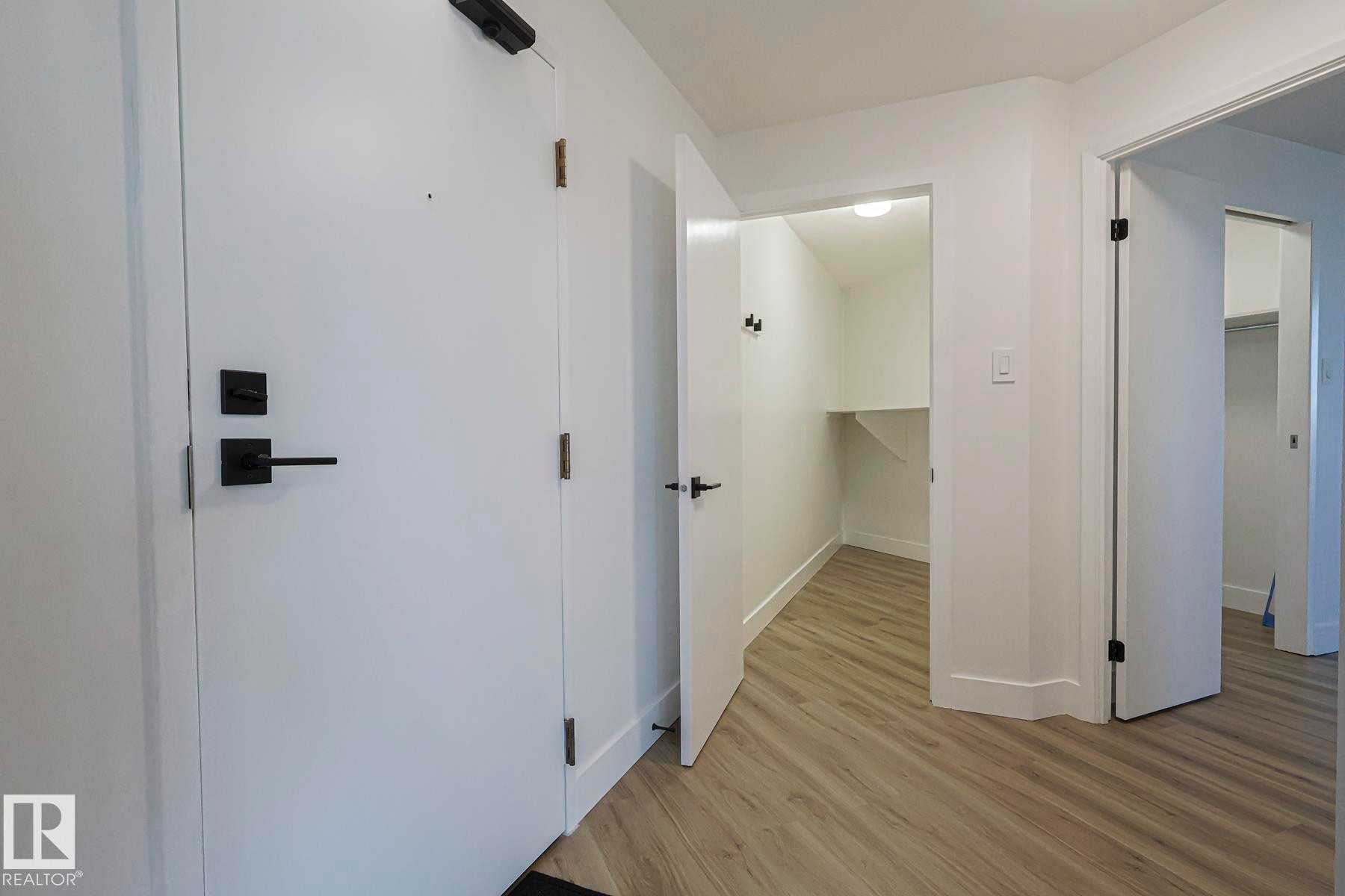 Corridor with light wood-style vinyl plank floors and baseboards - 505 10149 Saskatchewan Drive, Edmonton, AB - Indoor Photo Showing Other Room