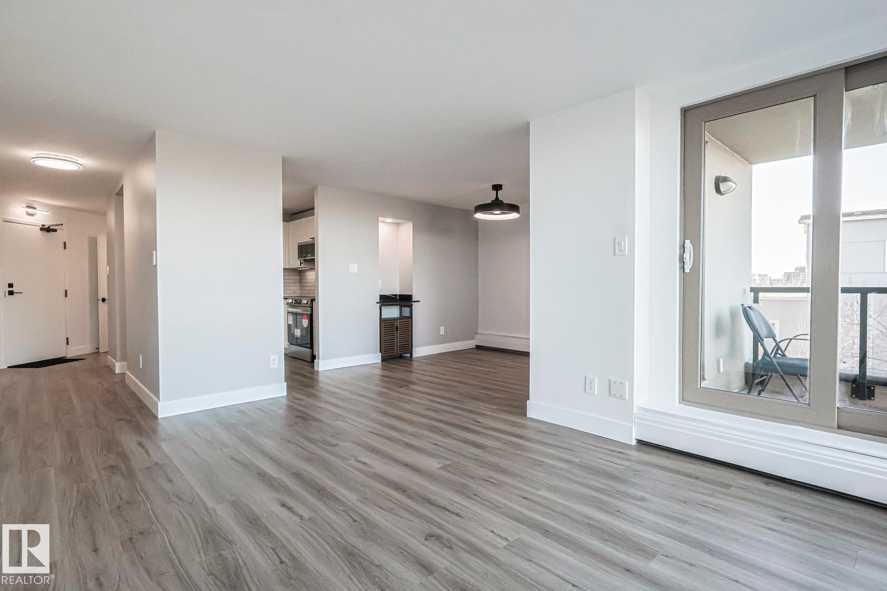 Living room featuring light vinyl plank flooring & access to balcony - 505 10149 Saskatchewan Drive, Edmonton, AB - Indoor