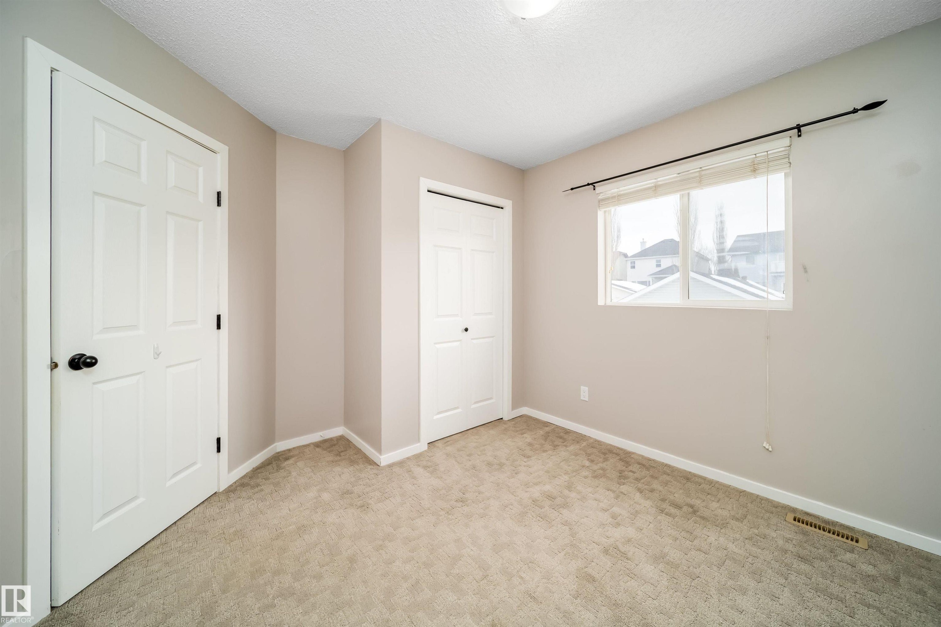 Unfurnished bedroom with carpet flooring, a closet, and a textured ceiling - 1695 Tompkins Place, Edmonton, AB - Indoor Photo Showing Other Room