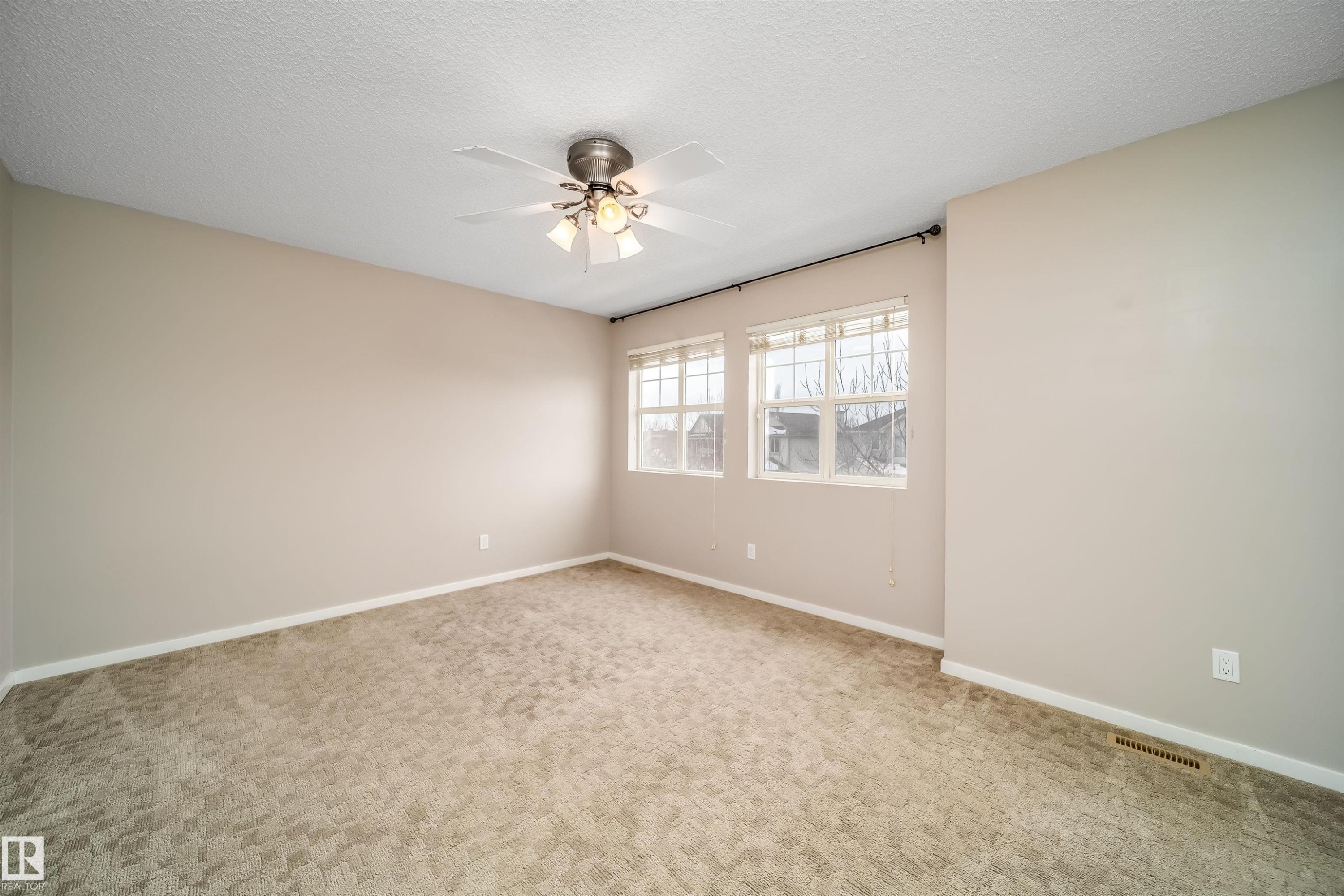 Unfurnished room with a textured ceiling, light colored carpet, and ceiling fan - 1695 Tompkins Place, Edmonton, AB - Indoor Photo Showing Other Room