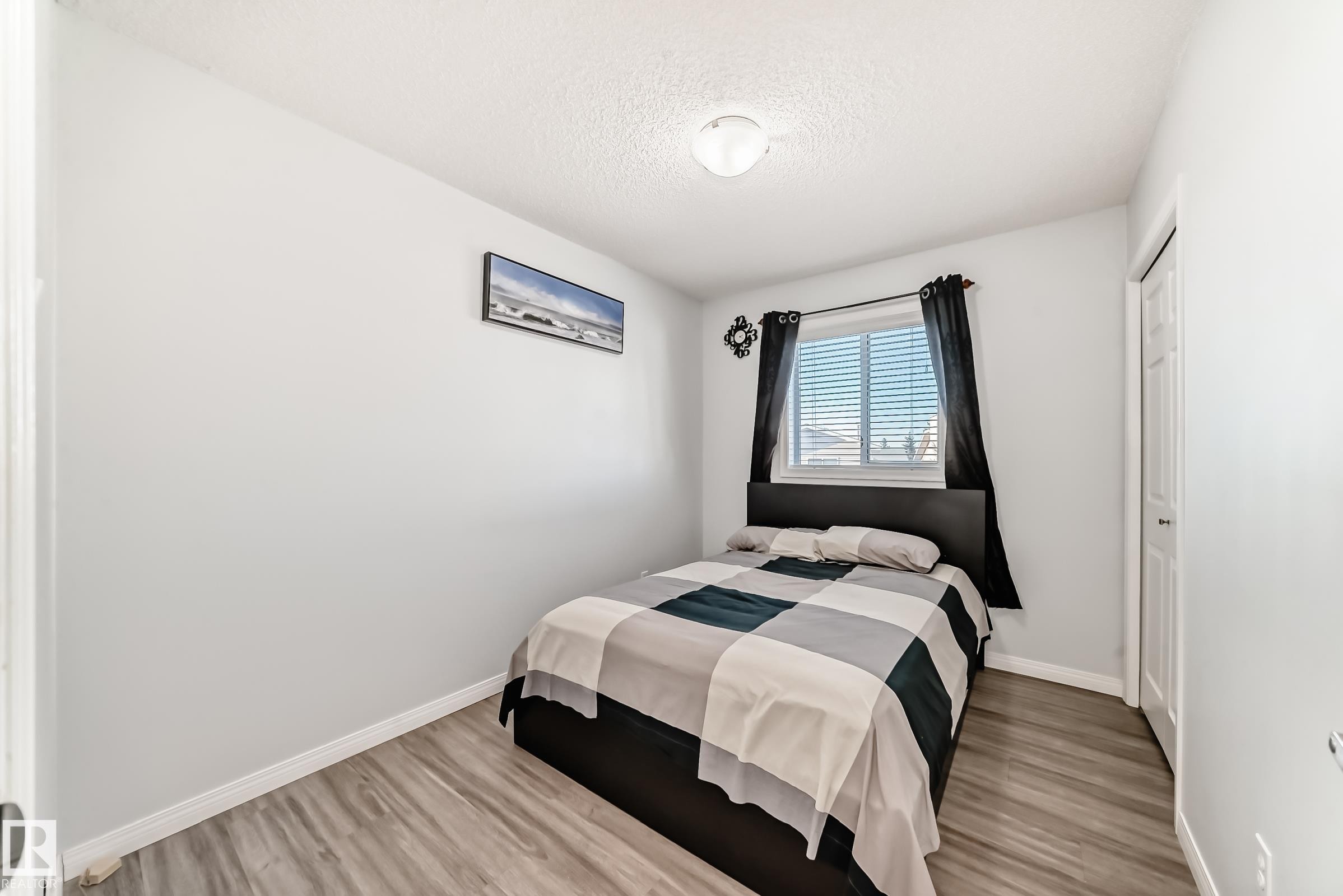 Bedroom with light wood-style floors, a textured ceiling, and a closet - 6 Jefferson Road, Edmonton, AB - Indoor Photo Showing Bedroom