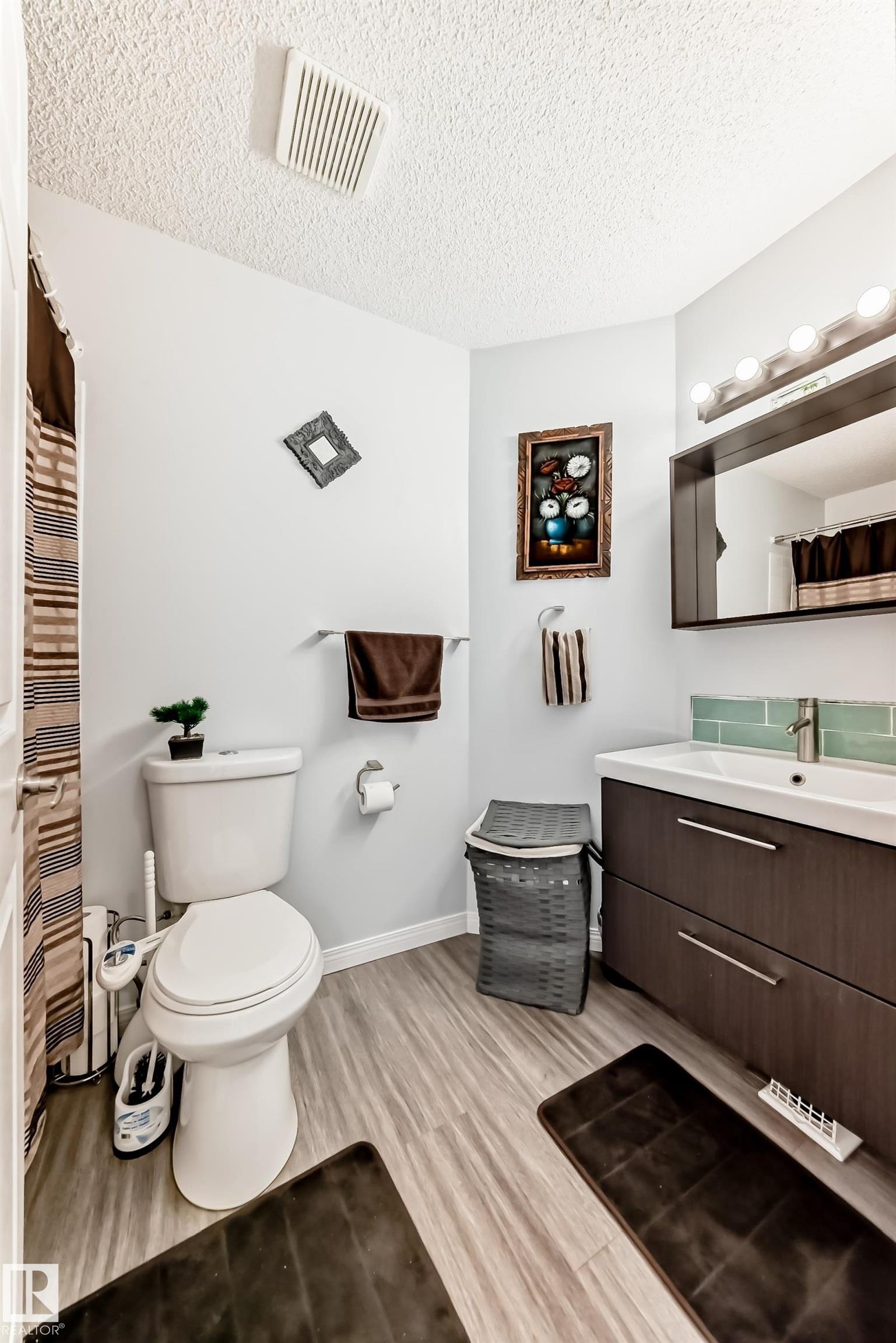Bathroom with a shower with shower curtain, vanity, a textured ceiling, and light wood-style floors - 6 Jefferson Road, Edmonton, AB - Indoor Photo Showing Bathroom
