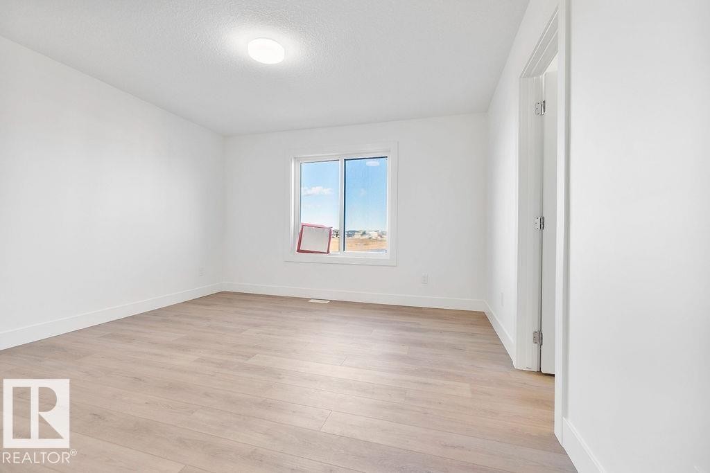 Spare room featuring light wood-style flooring and a textured ceiling - 235 Linden Loop, Leduc, AB - Indoor Photo Showing Other Room