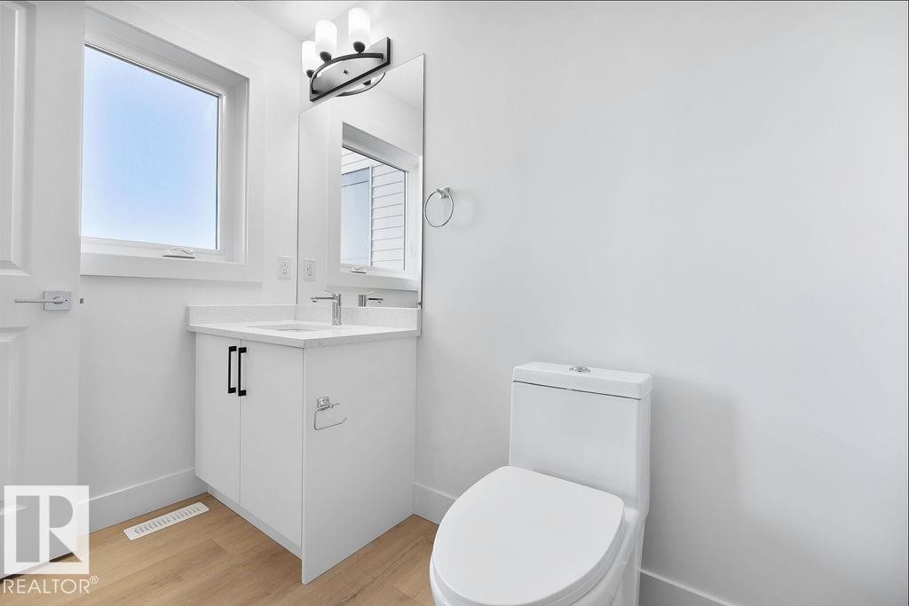 Half bath with vanity and light wood-type flooring - 235 Linden Loop, Leduc, AB - Indoor Photo Showing Bathroom
