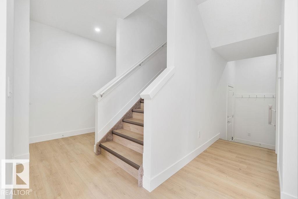 Stairs with wood finished floors and recessed lighting - 235 Linden Loop, Leduc, AB - Indoor Photo Showing Other Room