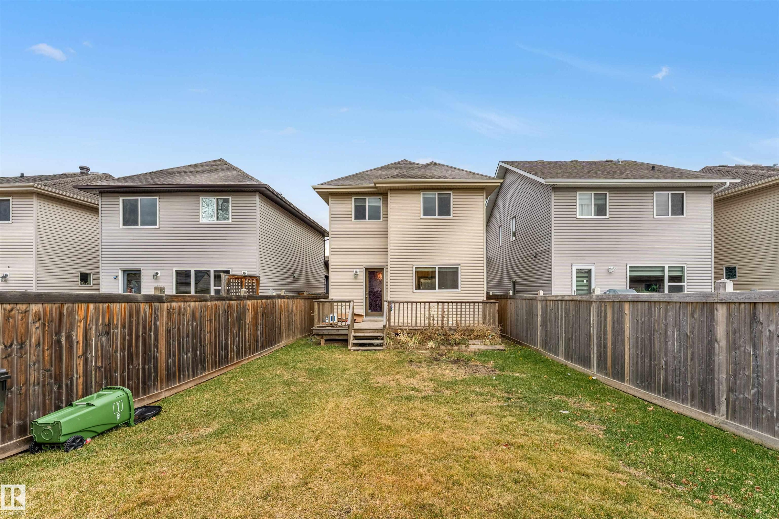 Rear view of house featuring a residential view, a fenced backyard, and a deck - 610 Tamarack Road, Edmonton, AB - Outdoor With Exterior