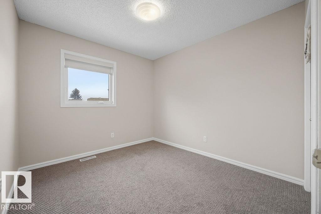 Carpeted empty room featuring a textured ceiling and baseboards - 736 Johns Road, Edmonton, AB - Indoor Photo Showing Other Room
