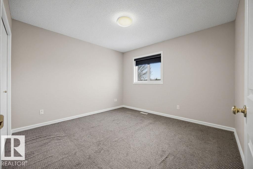 Empty room featuring a textured ceiling and carpet - 736 Johns Road, Edmonton, AB - Indoor Photo Showing Other Room