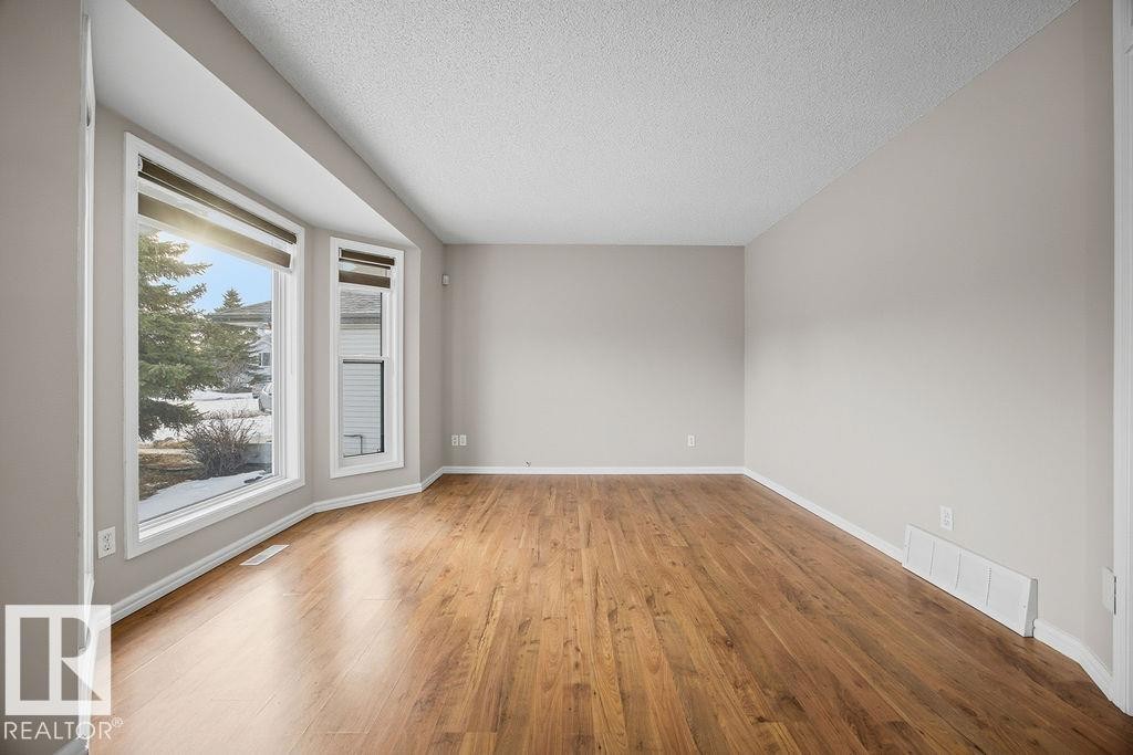 Empty room with wood finished floors and a textured ceiling - 736 Johns Road, Edmonton, AB - Indoor Photo Showing Other Room