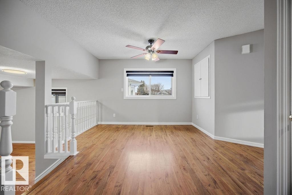 Unfurnished room featuring a textured ceiling, light wood-type flooring, and a ceiling fan - 736 Johns Road, Edmonton, AB - Indoor Photo Showing Other Room