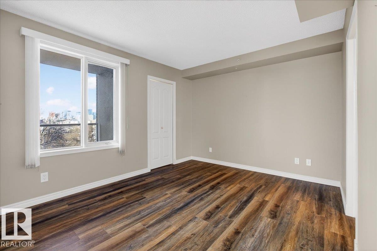 Spare room with dark wood-type flooring - 402 10649 Saskatchewan Drive, Edmonton, AB - Indoor Photo Showing Other Room