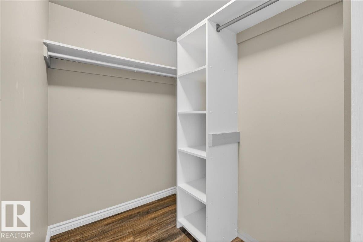 Walk in closet with dark wood-type flooring - 402 10649 Saskatchewan Drive, Edmonton, AB - Indoor With Storage