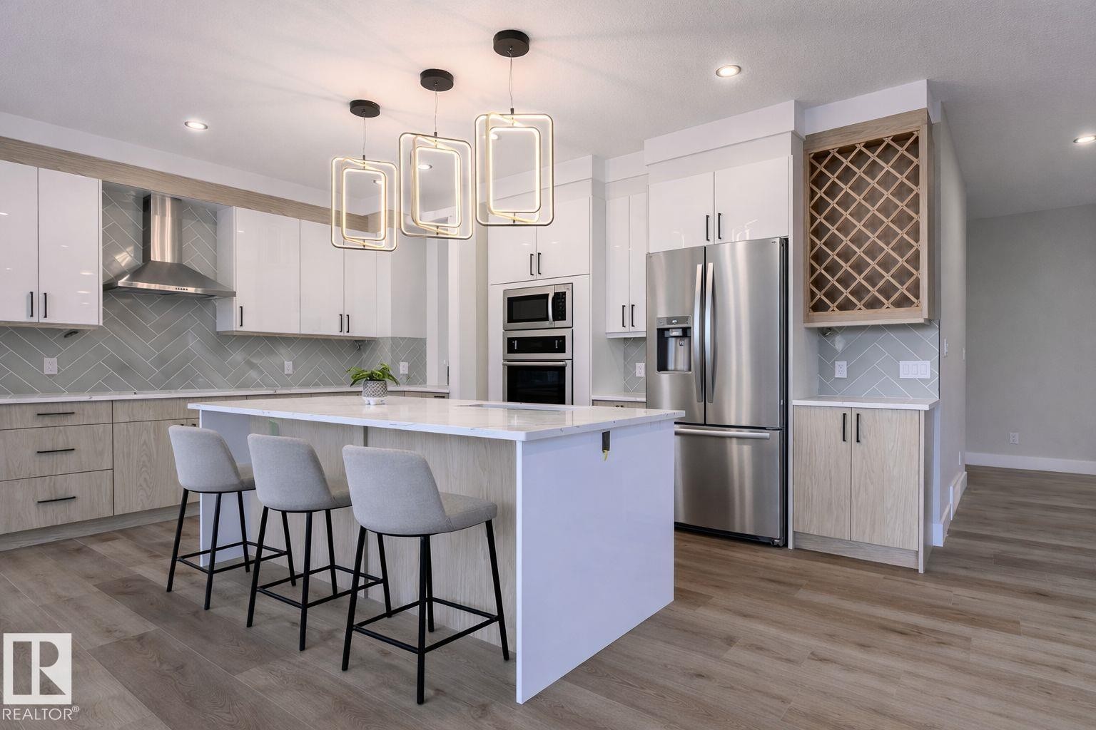 Kitchen with stainless steel appliances, a Wine Rack, and decorative light fixtures - 16 Middleton Close, Leduc, AB - Indoor Photo Showing Kitchen With Upgraded Kitchen