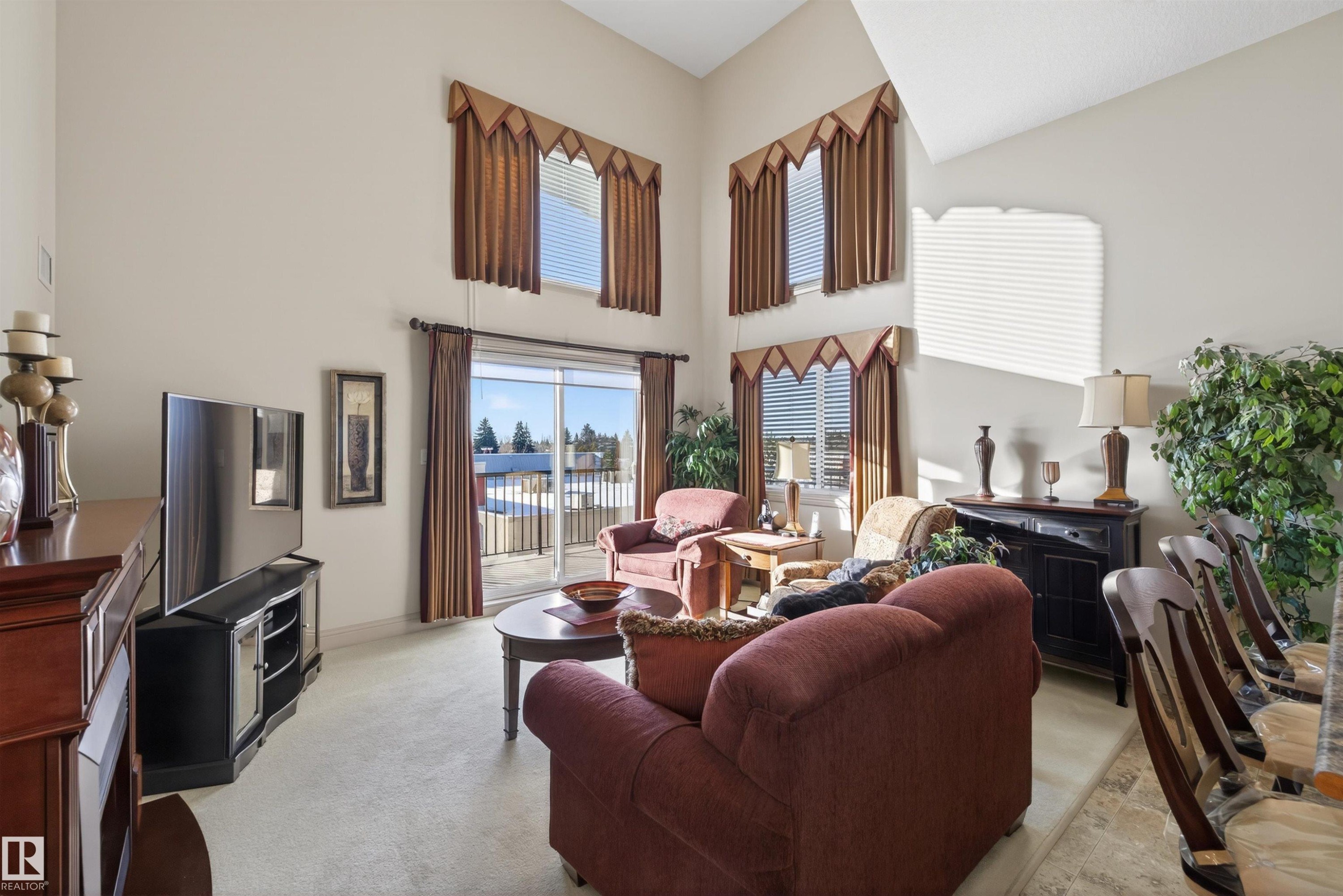 Living room featuring light colored carpet and a high ceiling - 427 13005 140 Avenue, Edmonton, AB - Indoor Photo Showing Living Room