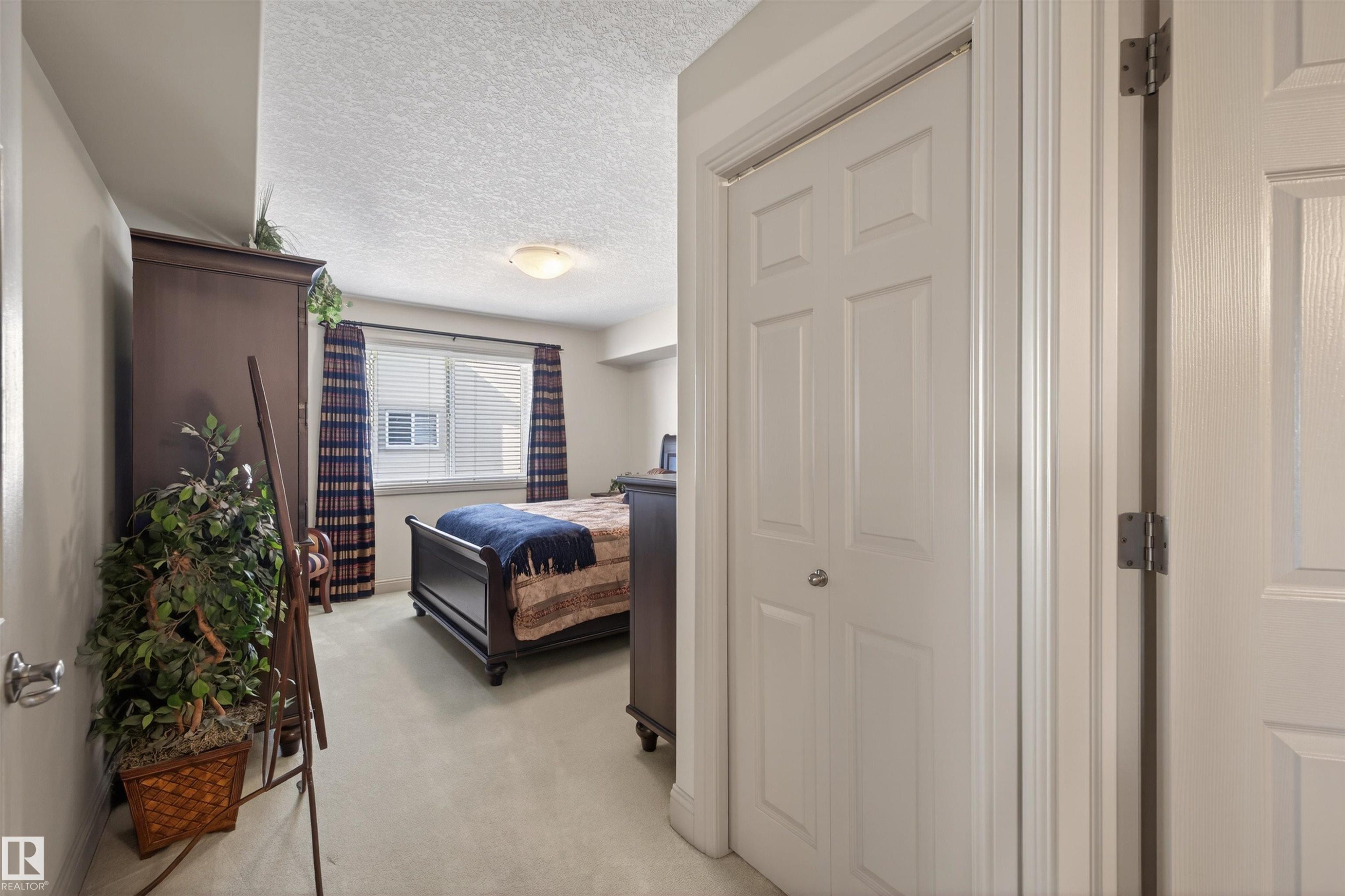 Bedroom featuring a textured ceiling and light carpet - 427 13005 140 Avenue, Edmonton, AB - Indoor