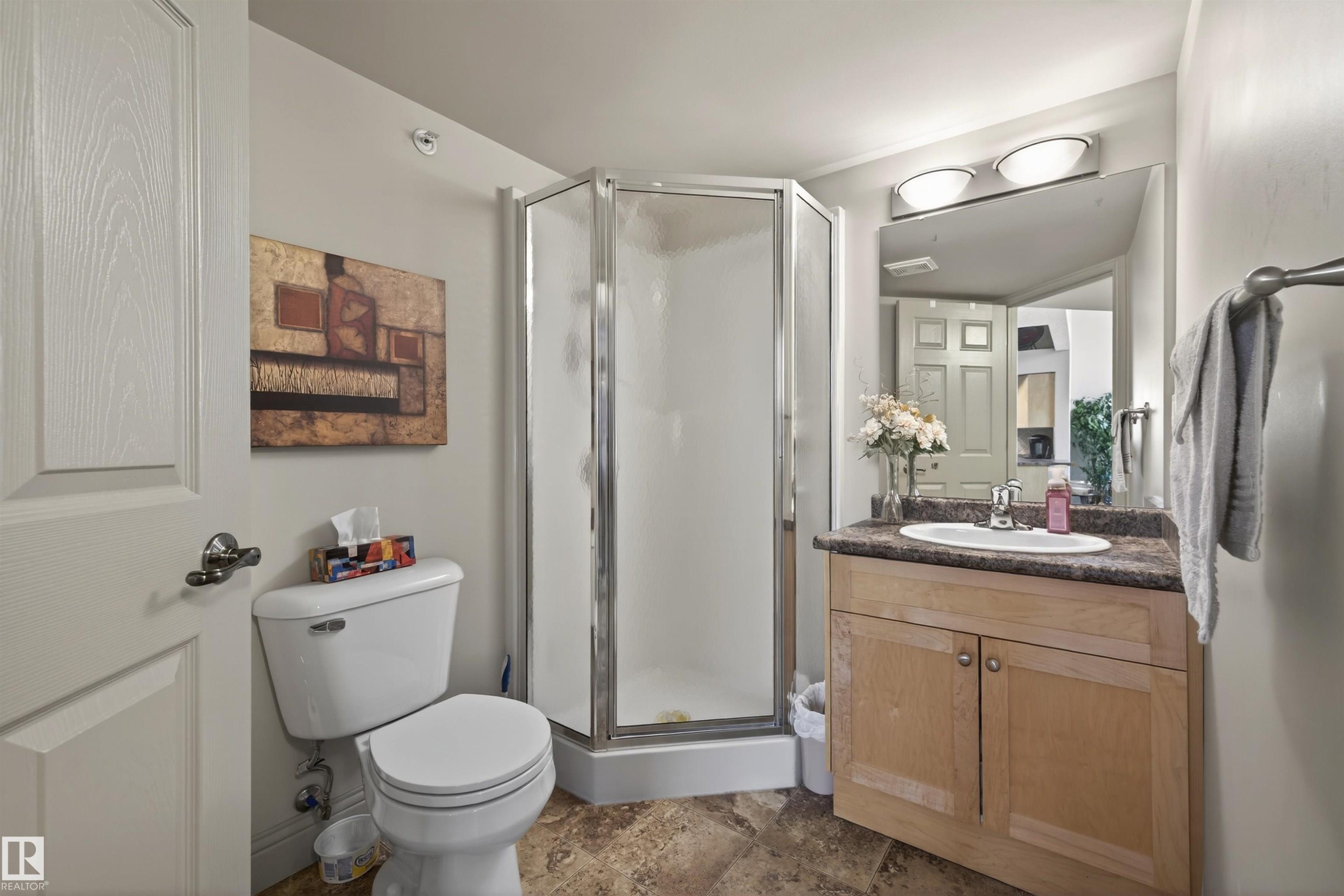 Full bathroom featuring vanity, a shower stall, and dark stone finish flooring - 427 13005 140 Avenue, Edmonton, AB - Indoor Photo Showing Bathroom