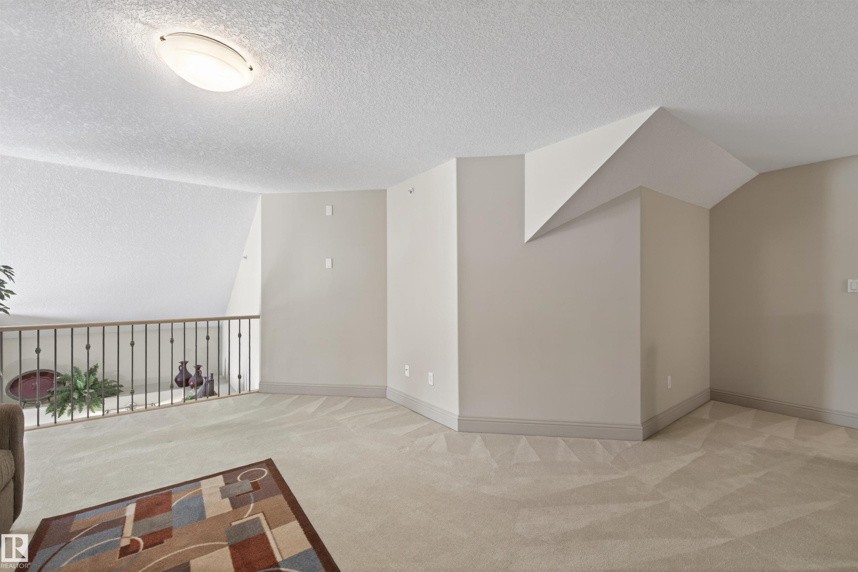 Spare room featuring light colored carpet and baseboards - 427 13005 140 Avenue, Edmonton, AB - Indoor Photo Showing Other Room
