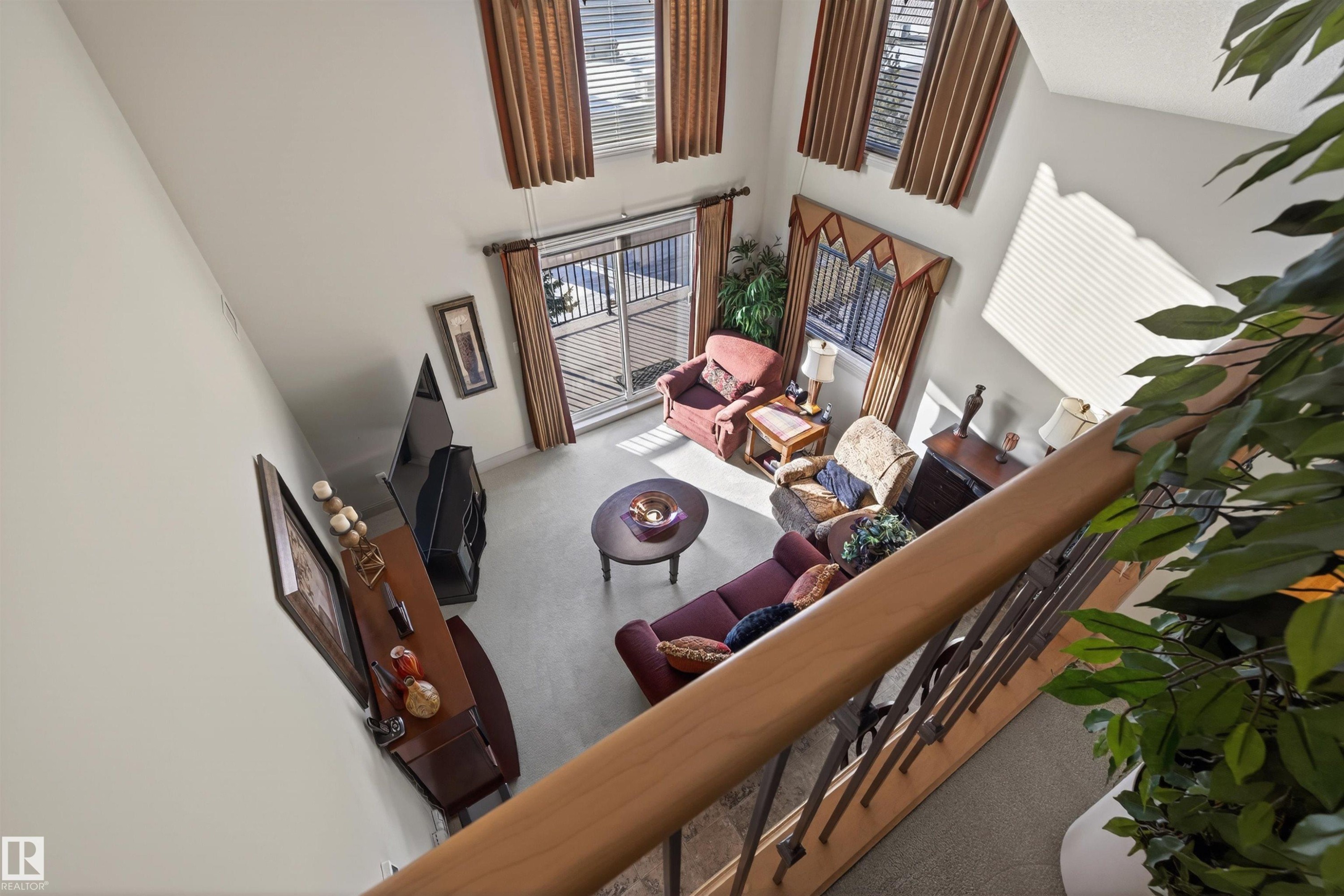Carpeted living room with a high ceiling - 427 13005 140 Avenue, Edmonton, AB - Indoor Photo Showing Other Room
