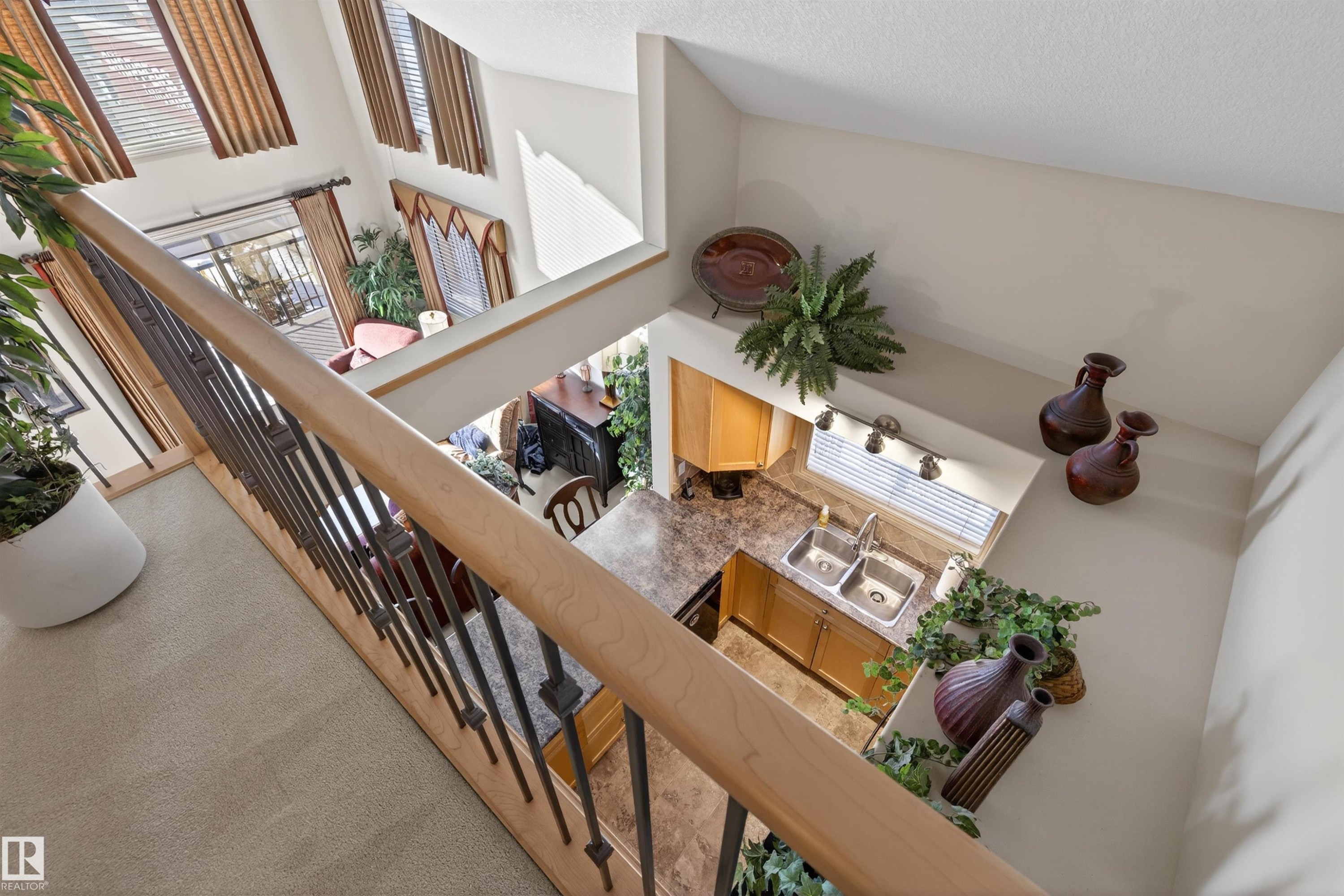 Stairway with a high ceiling and carpet flooring - 427 13005 140 Avenue, Edmonton, AB - Indoor Photo Showing Other Room