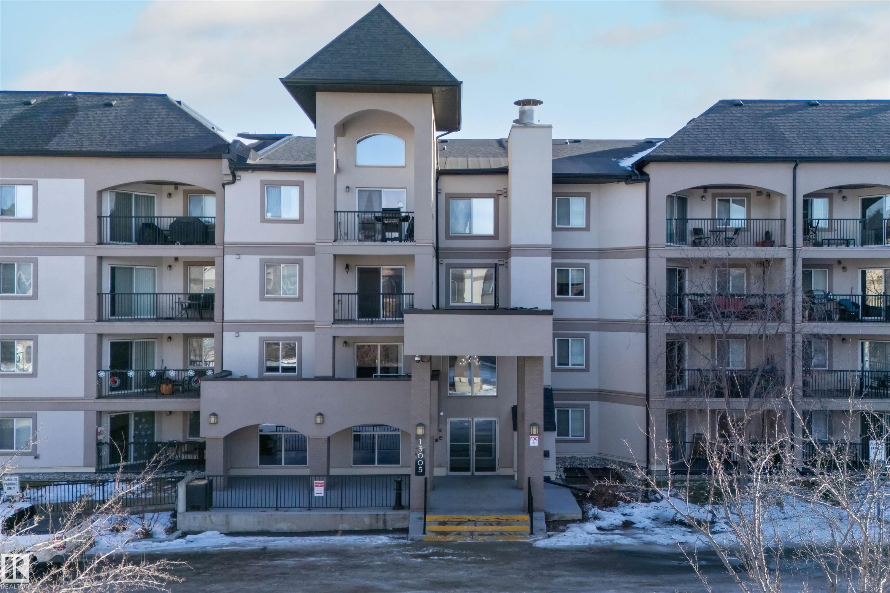 Snow covered property with a view of apartment building / complex - 427 13005 140 Avenue, Edmonton, AB - Outdoor With Facade