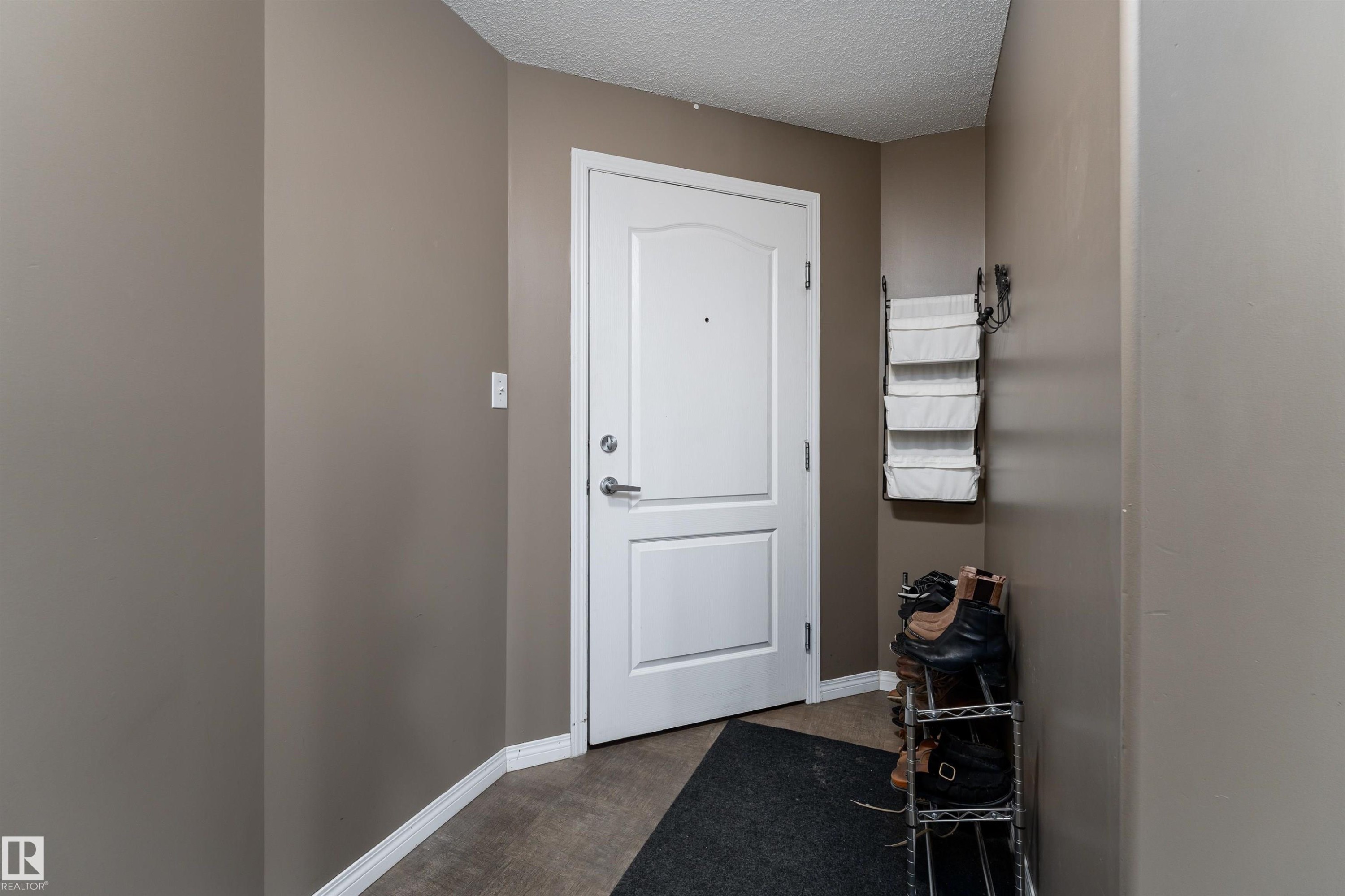 Doorway with a textured ceiling and baseboards - 325 1520 Hammond Gate, Edmonton, AB - Indoor Photo Showing Other Room