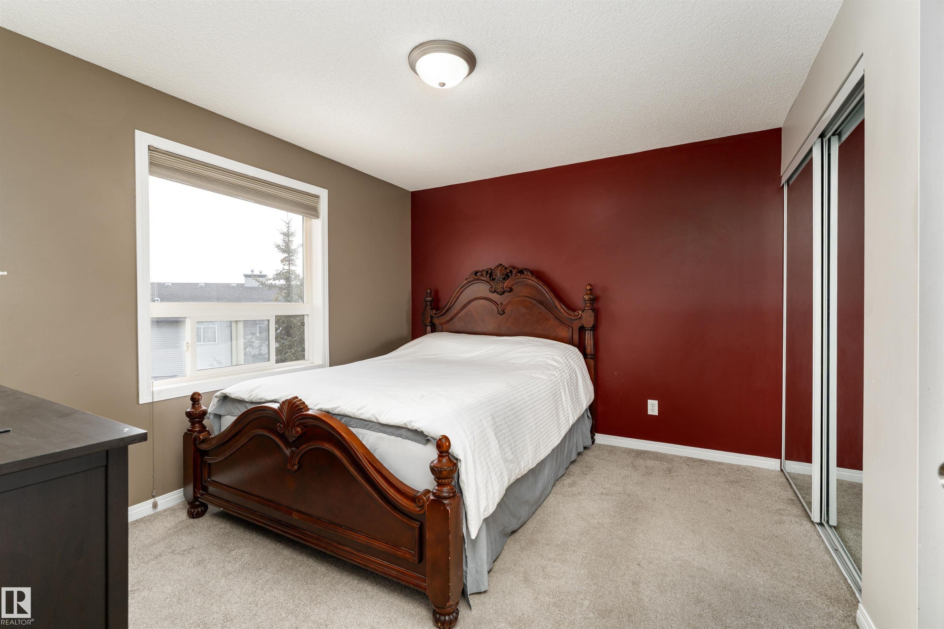Bedroom featuring a closet, light carpet, and an accent wall - 325 1520 Hammond Gate, Edmonton, AB - Indoor Photo Showing Bedroom