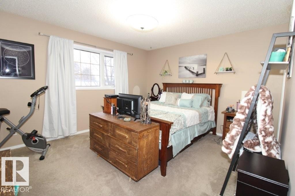 Bedroom featuring light colored carpet and a textured ceiling - 2812 35 Street Nw, Edmonton, AB - Indoor Photo Showing Bedroom