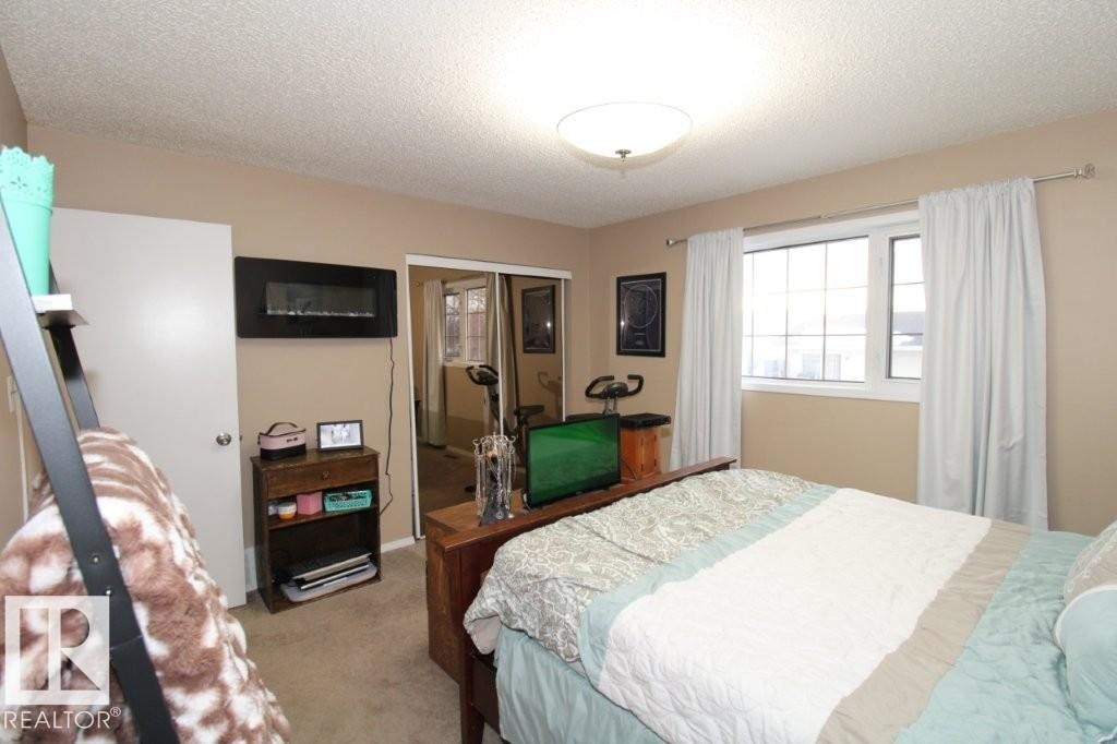 Bedroom with carpet floors, a closet, and a textured ceiling - 2812 35 Street Nw, Edmonton, AB - Indoor Photo Showing Bedroom
