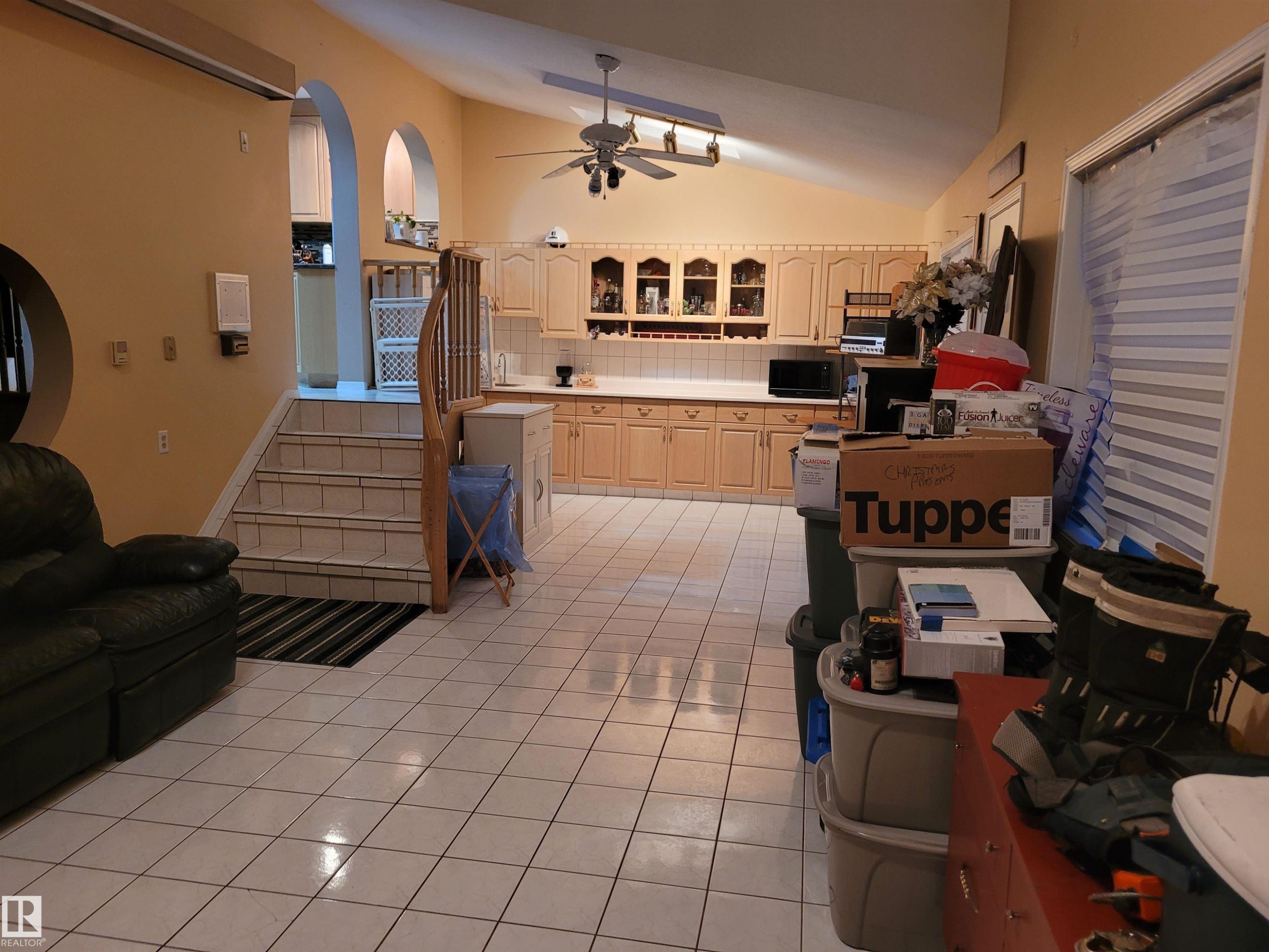 Kitchen featuring vaulted ceiling, light countertops, backsplash, ceiling fan, and light tile patterned flooring - 2812 35 Street Nw, Edmonton, AB - Indoor