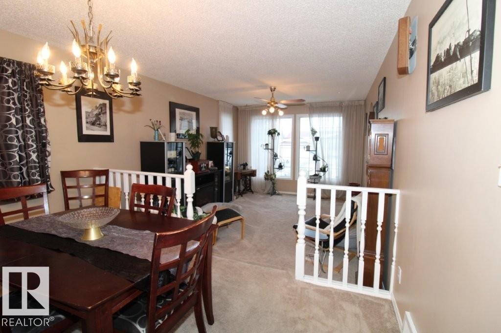Dining area featuring a textured ceiling, carpet flooring, ceiling fan, and a chandelier - 2812 35 Street Nw, Edmonton, AB - Indoor Photo Showing Dining Room