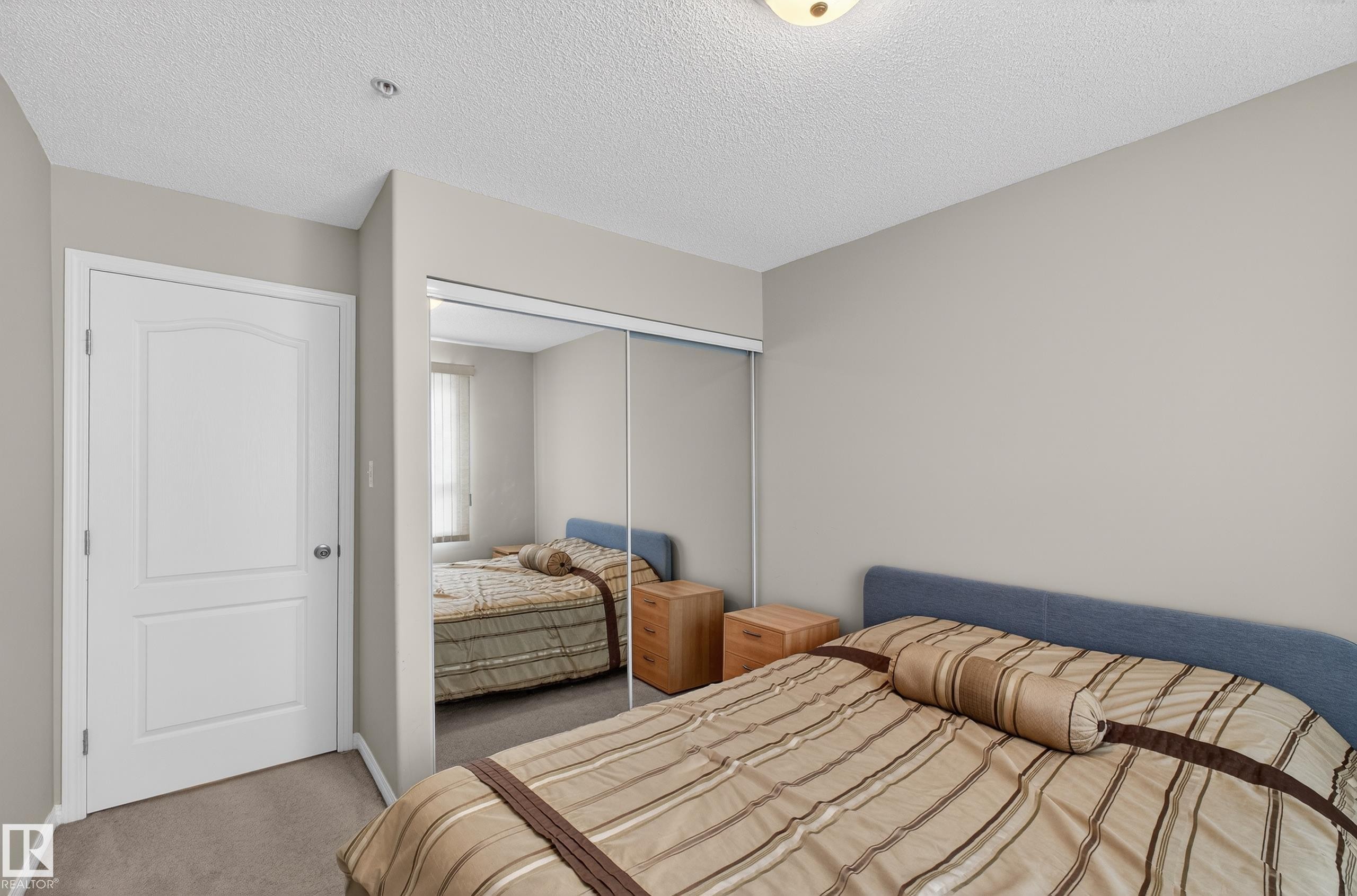 Bedroom with carpet floors, a closet, and a textured ceiling - 131 1520 Hammond Gate, Edmonton, AB - Indoor Photo Showing Bedroom