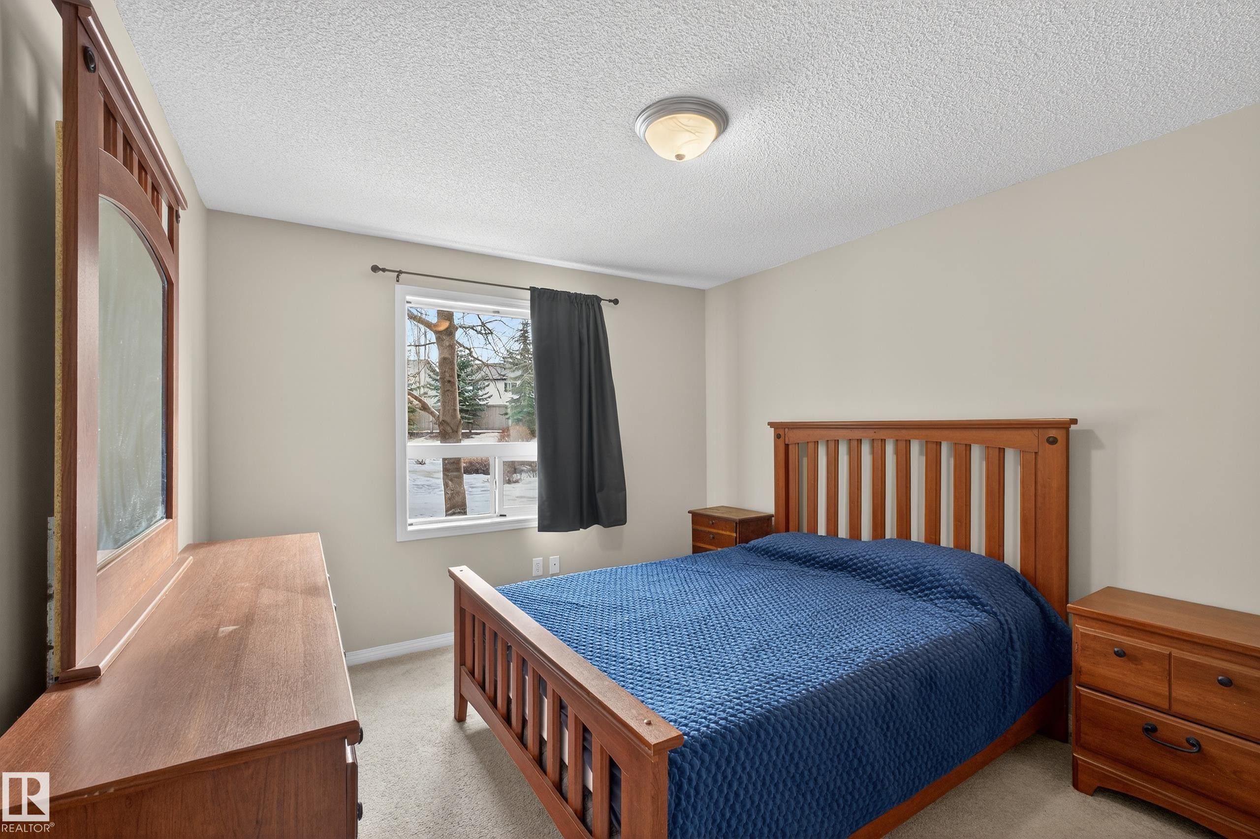 Bedroom with light carpet and a textured ceiling - 131 1520 Hammond Gate, Edmonton, AB - Indoor Photo Showing Bedroom