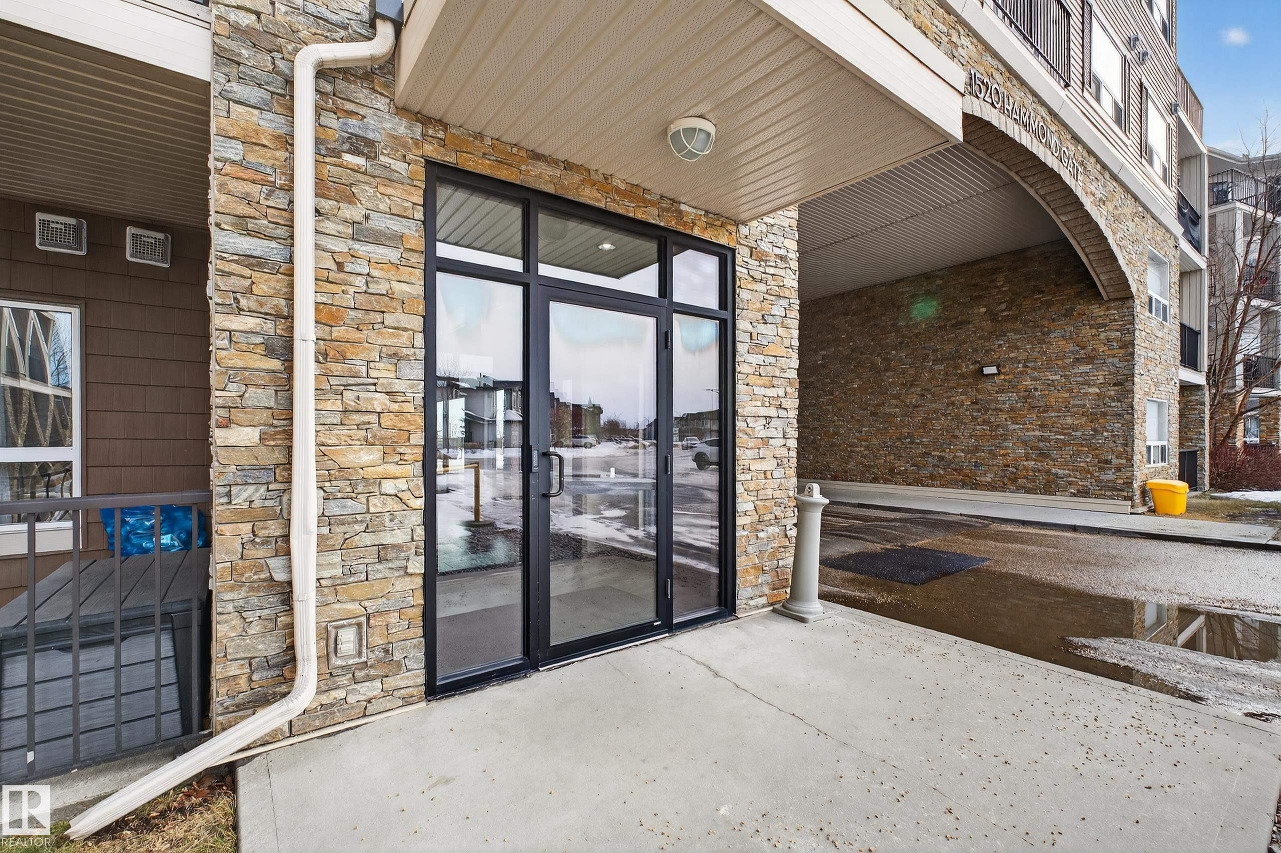 Entrance to property with stone siding and a patio area - 131 1520 Hammond Gate, Edmonton, AB - Outdoor
