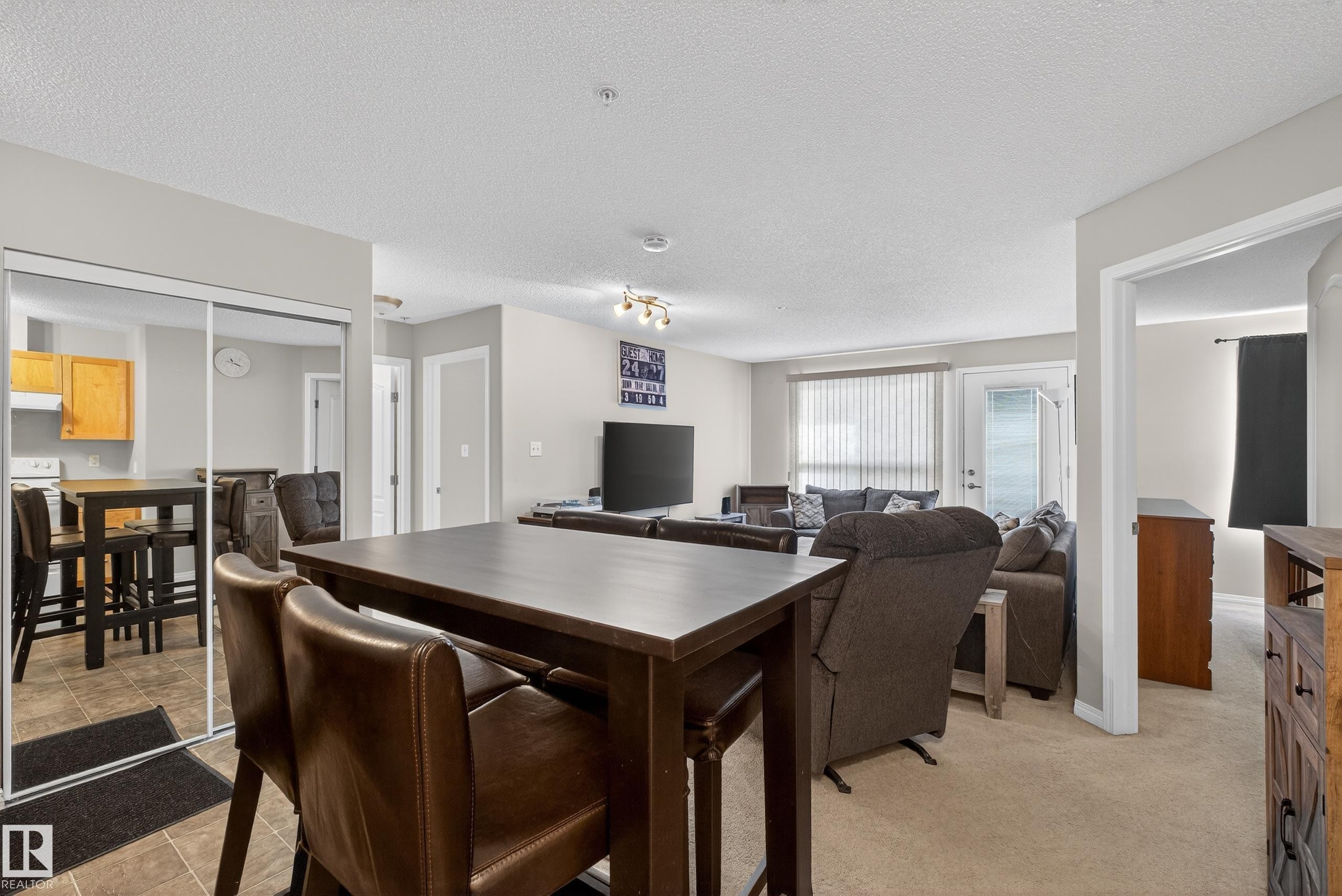 Dining room with a textured ceiling and baseboards - 131 1520 Hammond Gate, Edmonton, AB - Indoor Photo Showing Dining Room