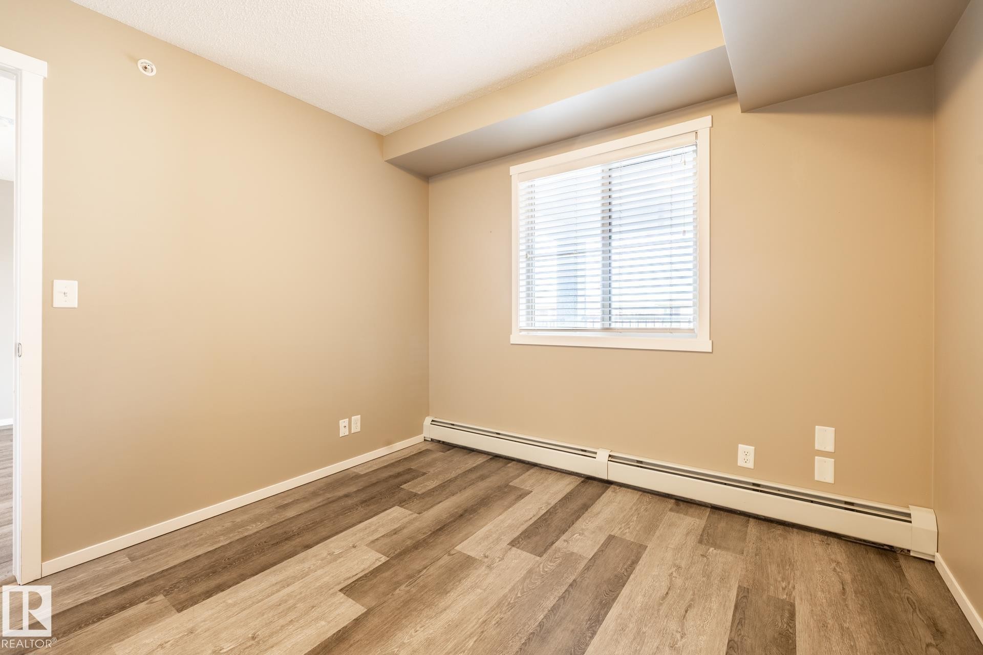 Unfurnished room with a baseboard radiator and light wood-style flooring - 433 3315 James Mowatt Trail, Edmonton, AB - Indoor Photo Showing Other Room